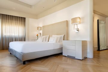 a bed with a headboard and lamps in a room