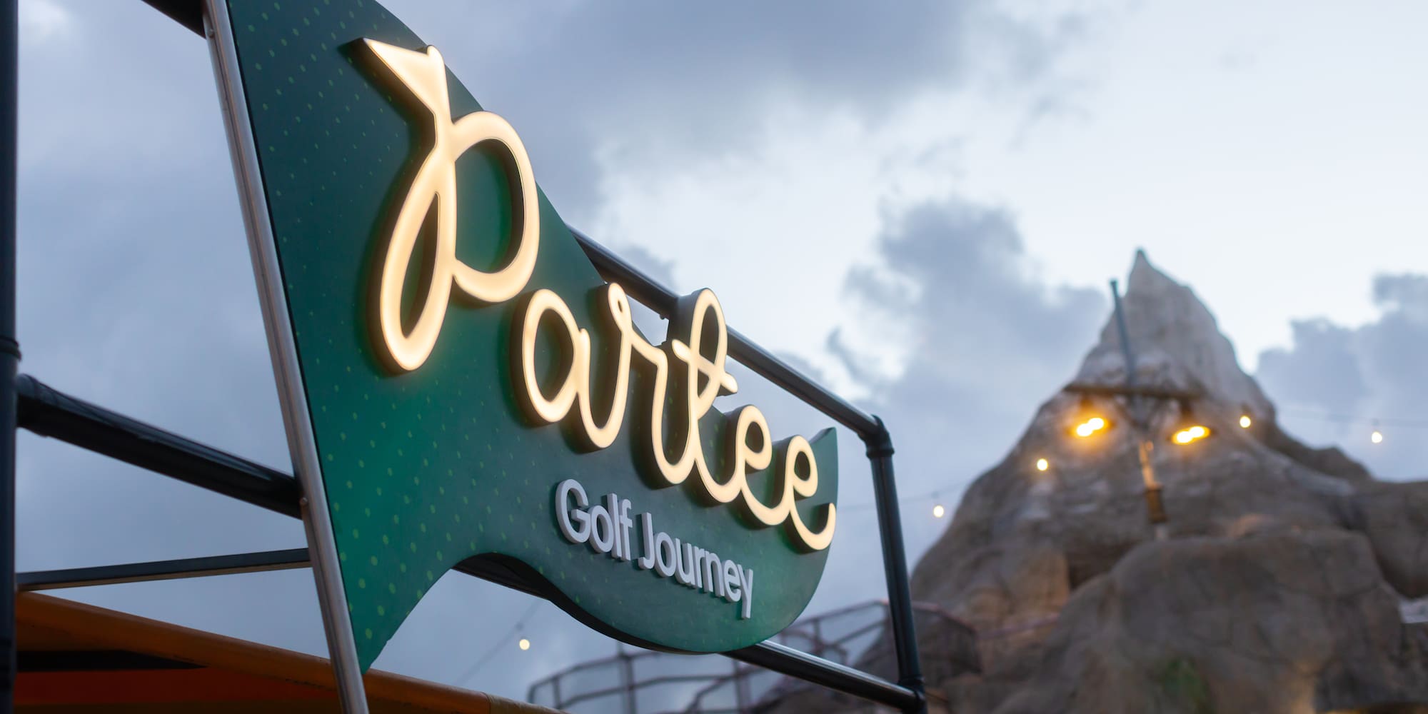 a sign with a mountain in the background