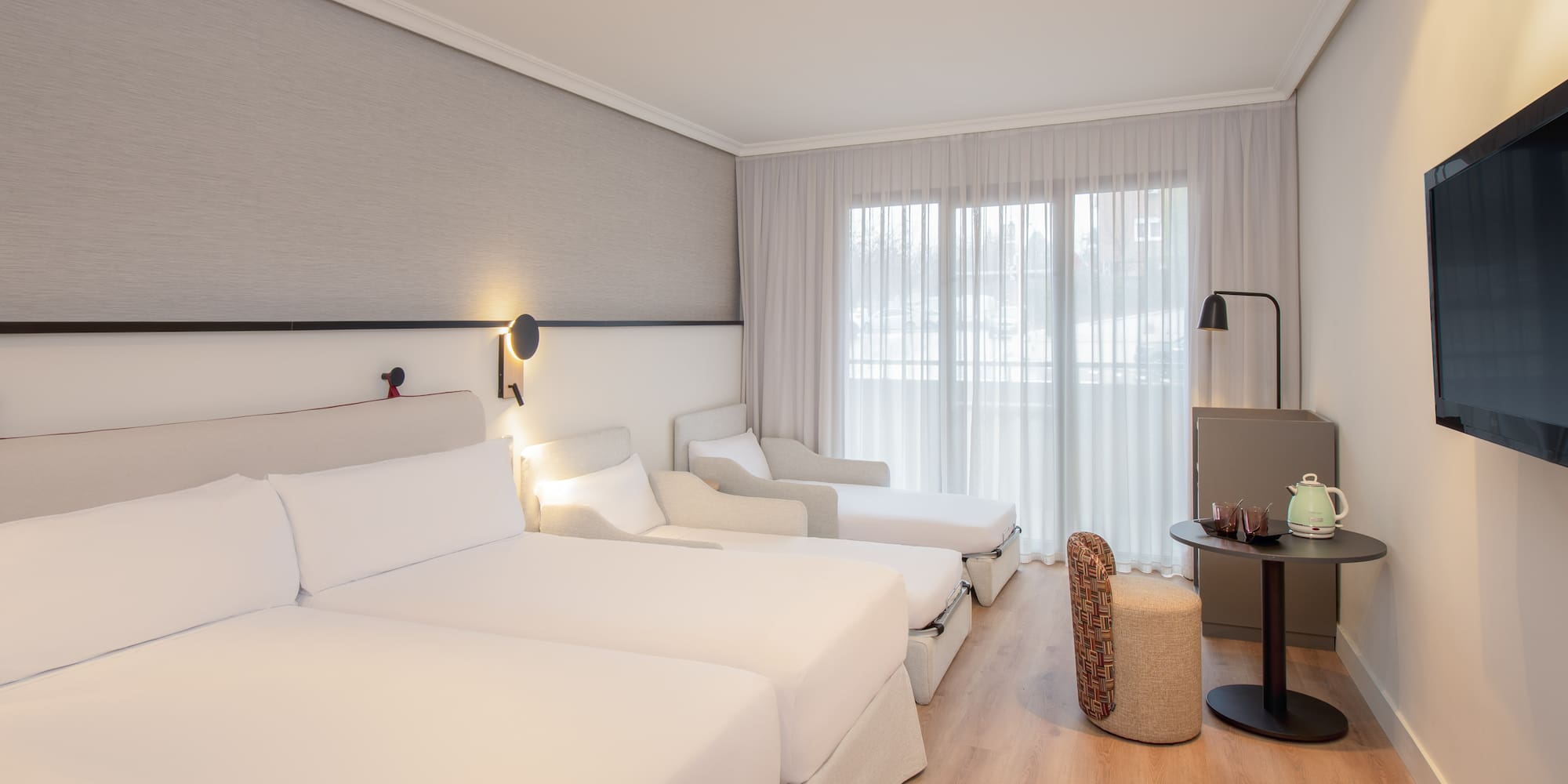 a room with white beds and a table