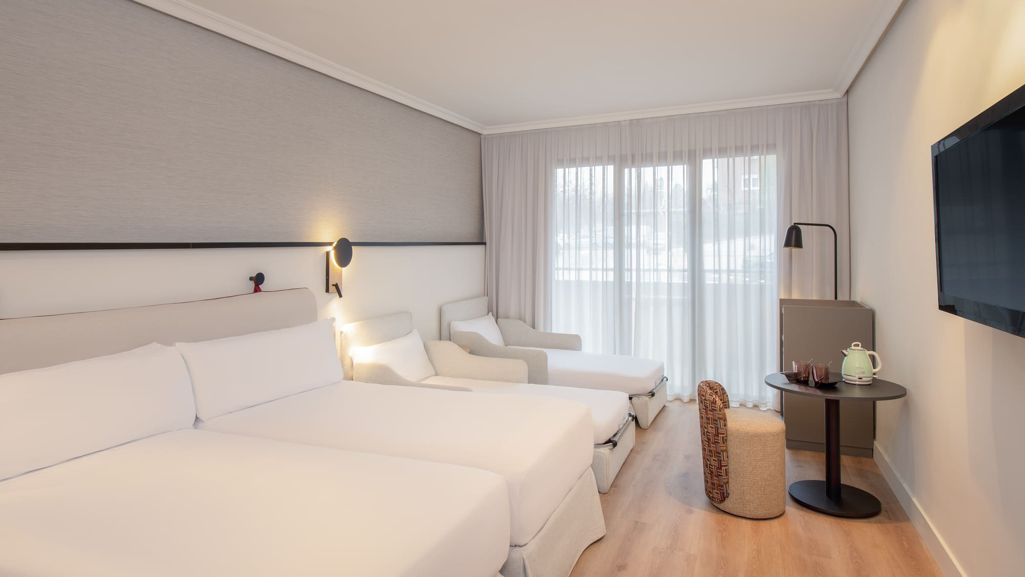 a room with white beds and a table