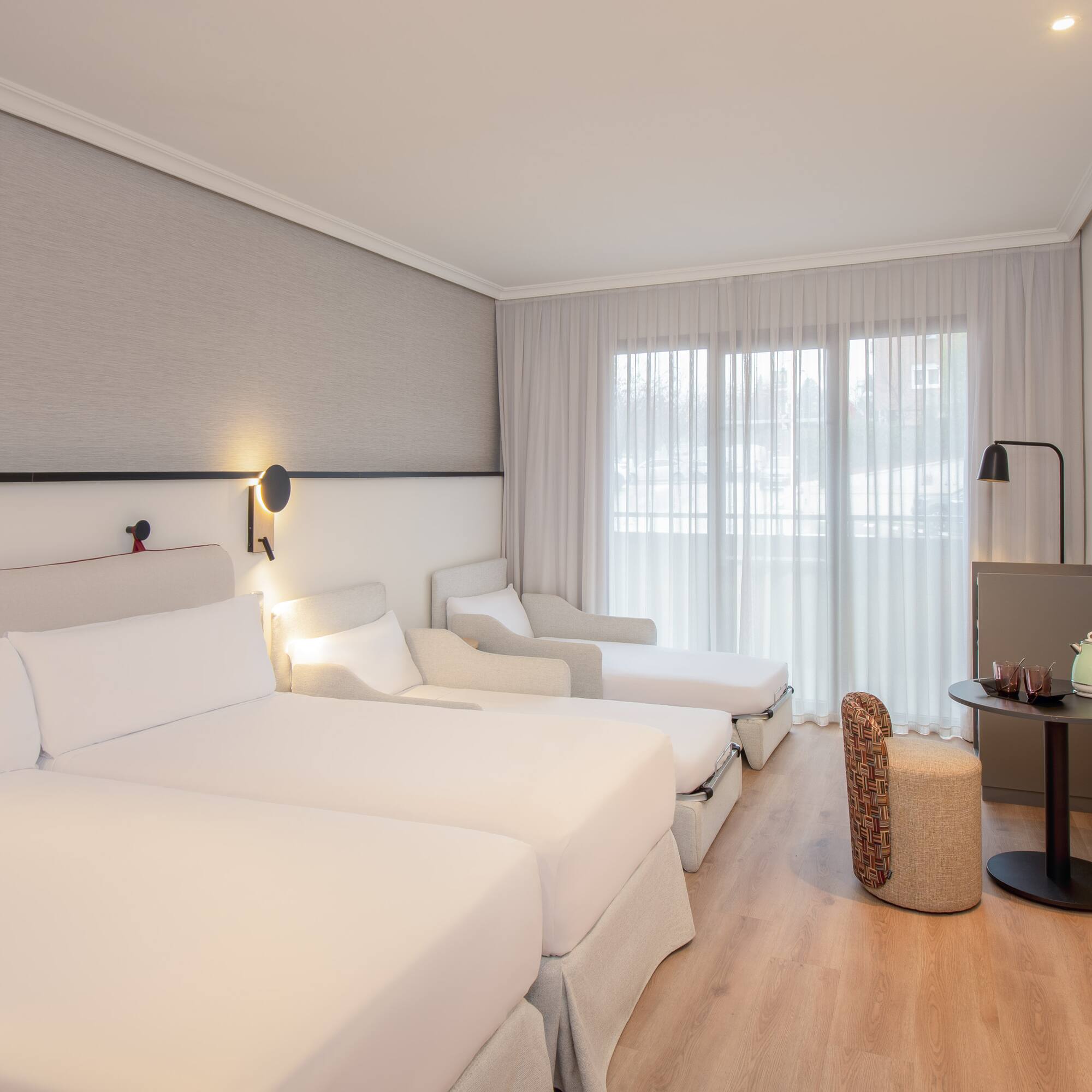 a room with white beds and a table