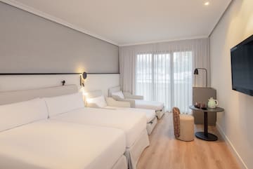 a room with white beds and a table