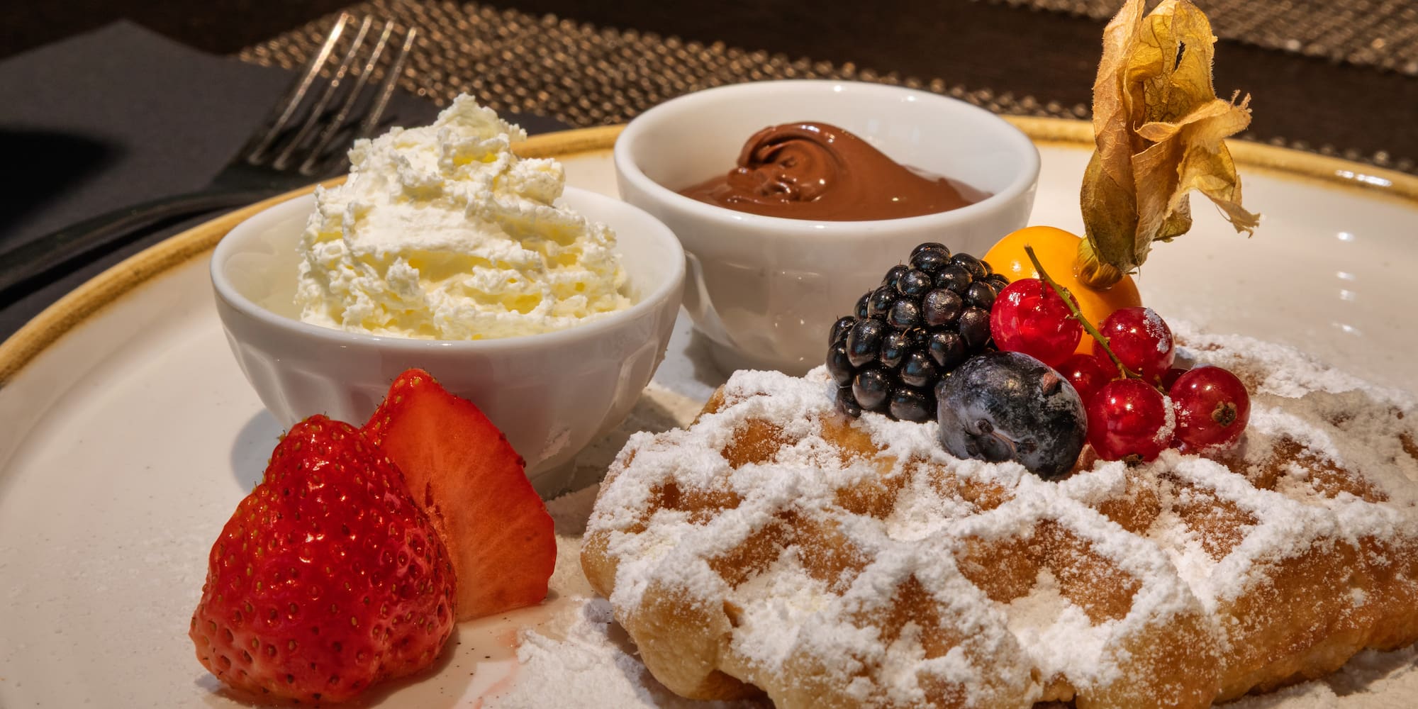 a plate of food with fruit and whipped cream