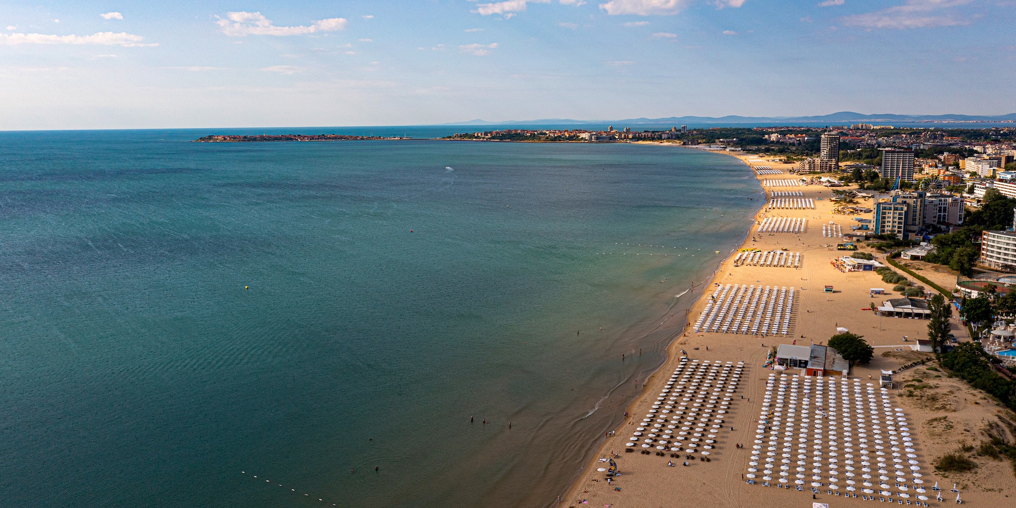 a beach with umbrellas and chairs and a body of water