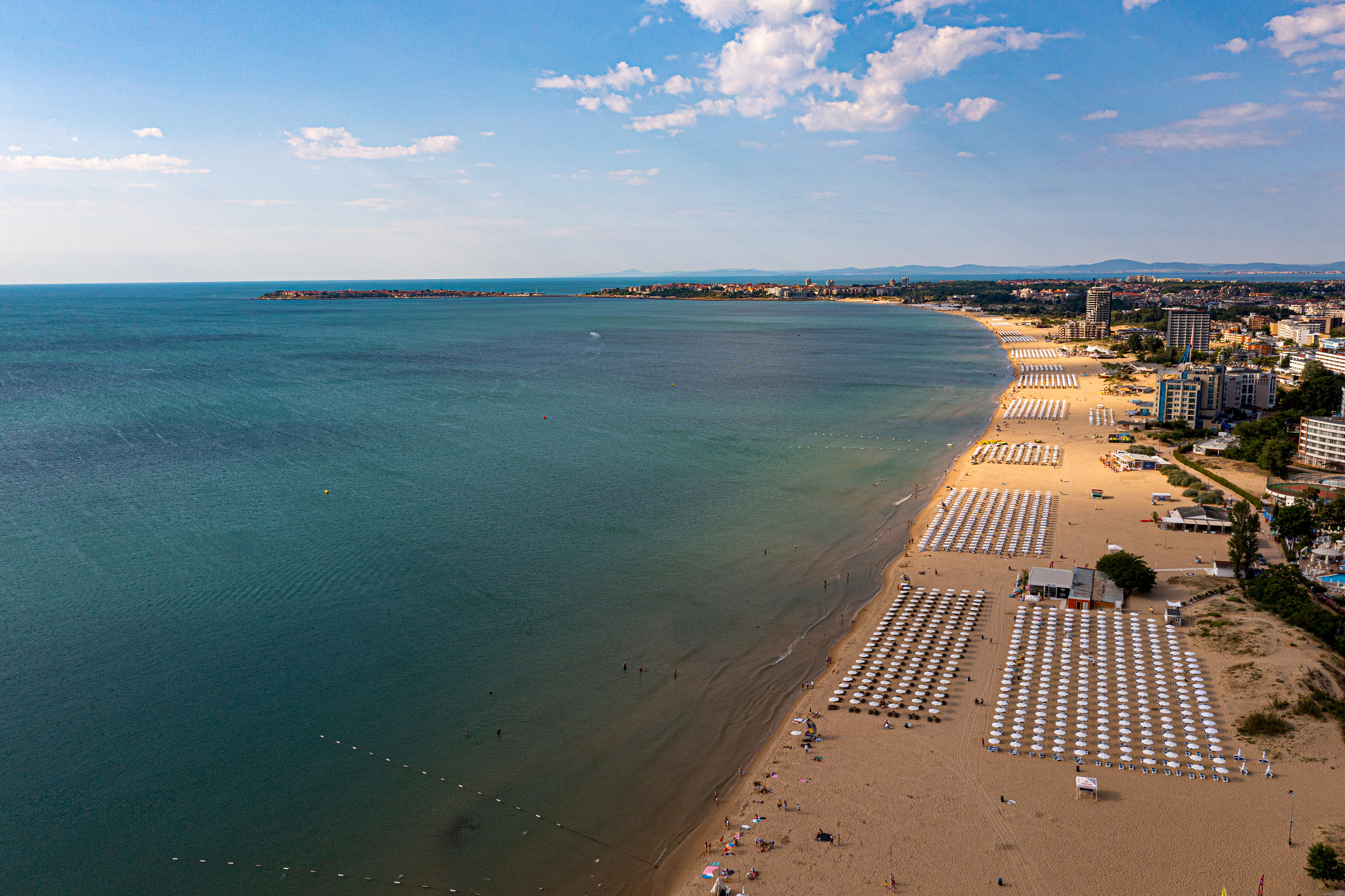 a beach with umbrellas and chairs and a body of water