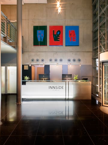 a lobby of a building with a reception desk and art on the wall