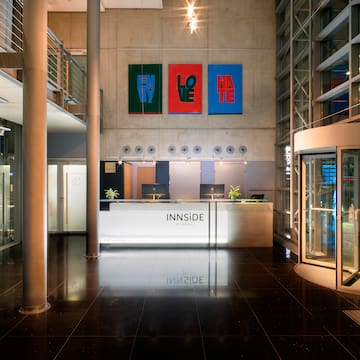 a lobby of a building with a reception desk and art on the wall