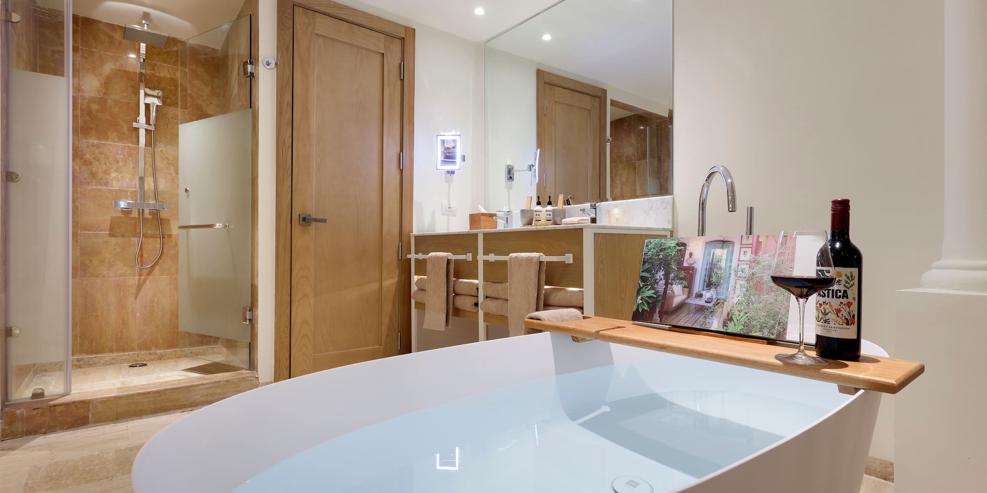 a bathroom with a tub and a glass of wine