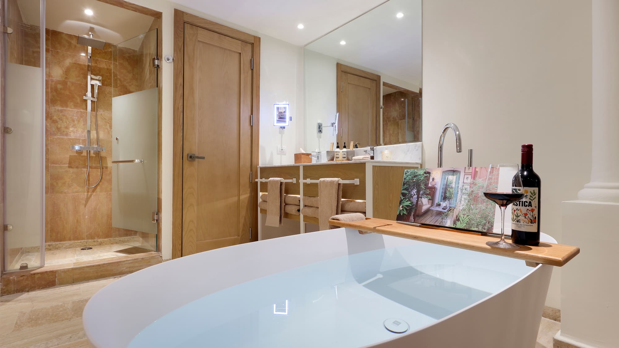 a bathroom with a tub and a glass of wine