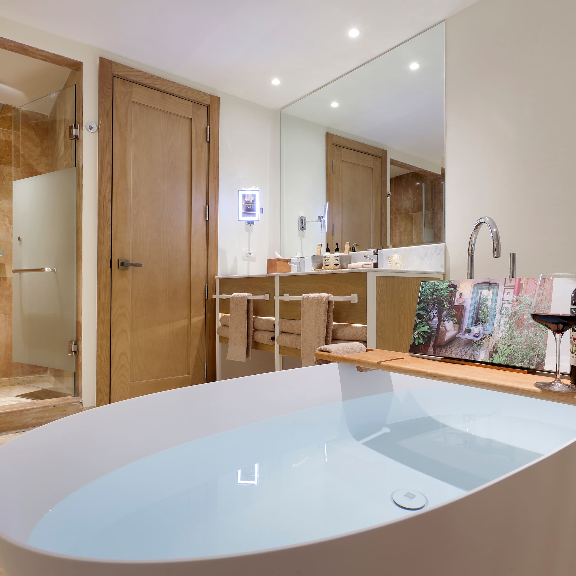 a bathroom with a tub and a glass of wine