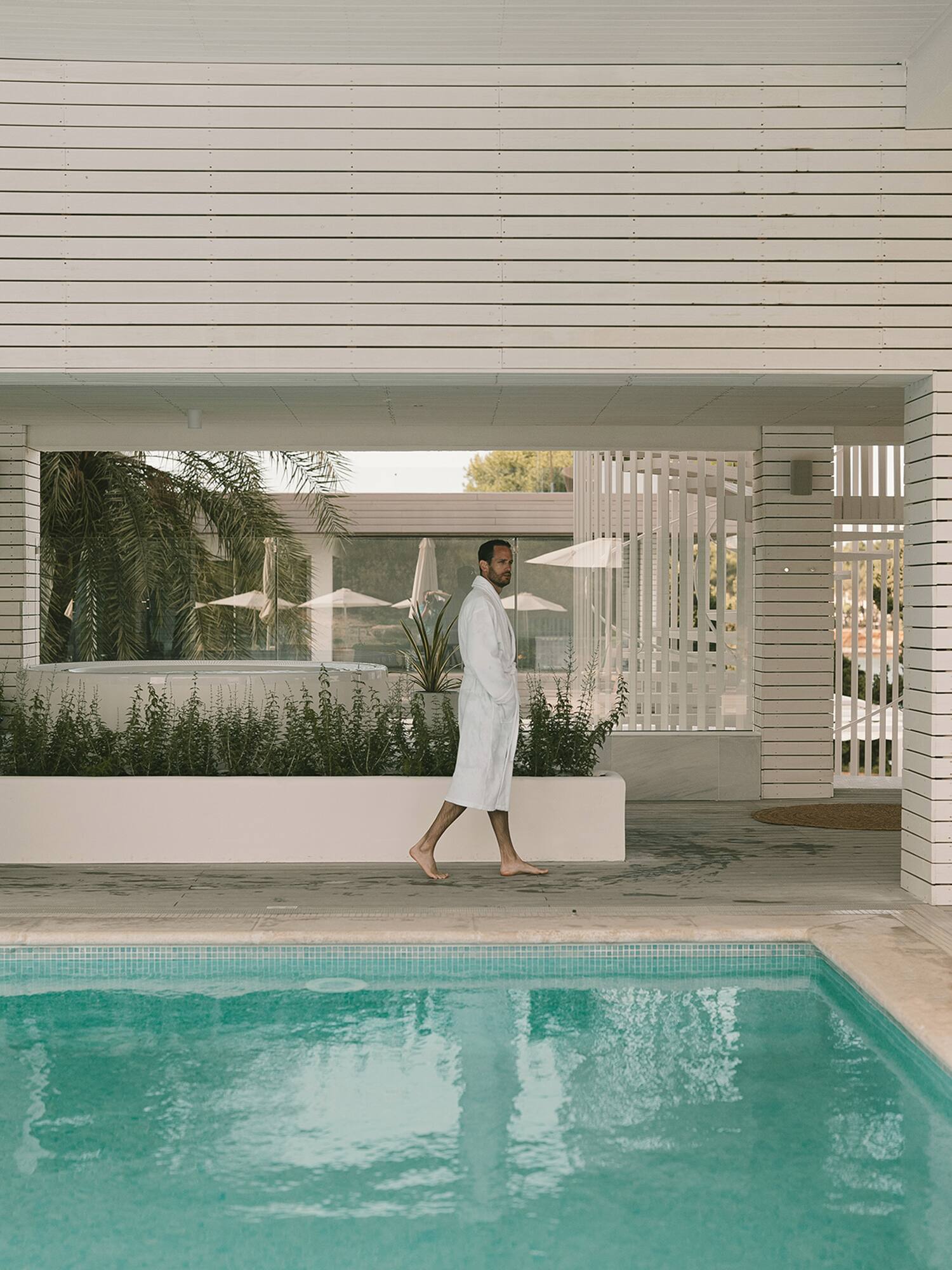 a man walking by a pool