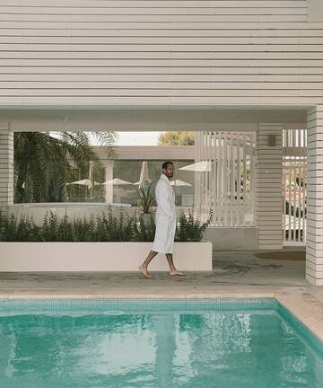 a man walking by a pool