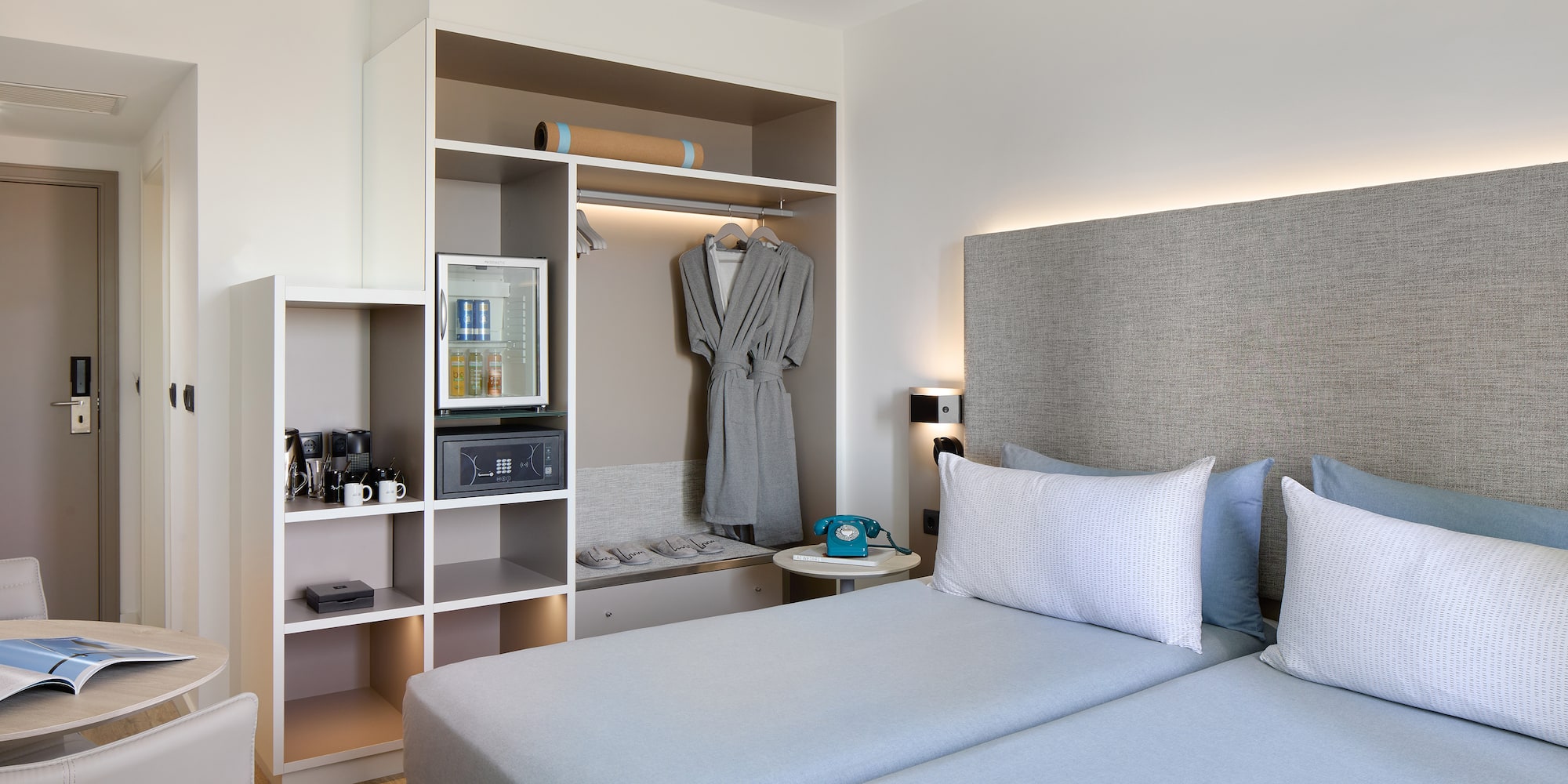 a room with two beds and a shelf