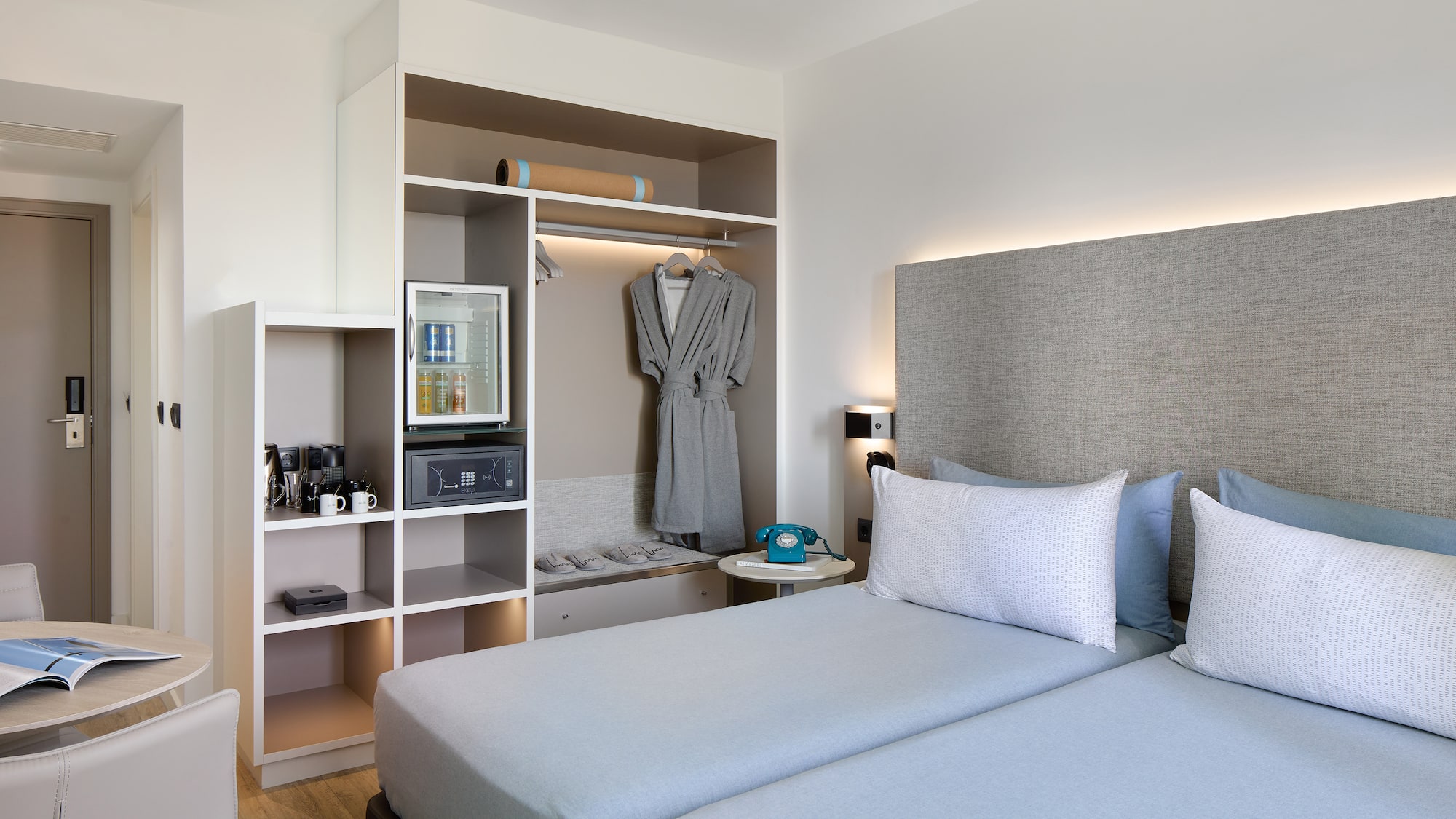 a room with two beds and a shelf