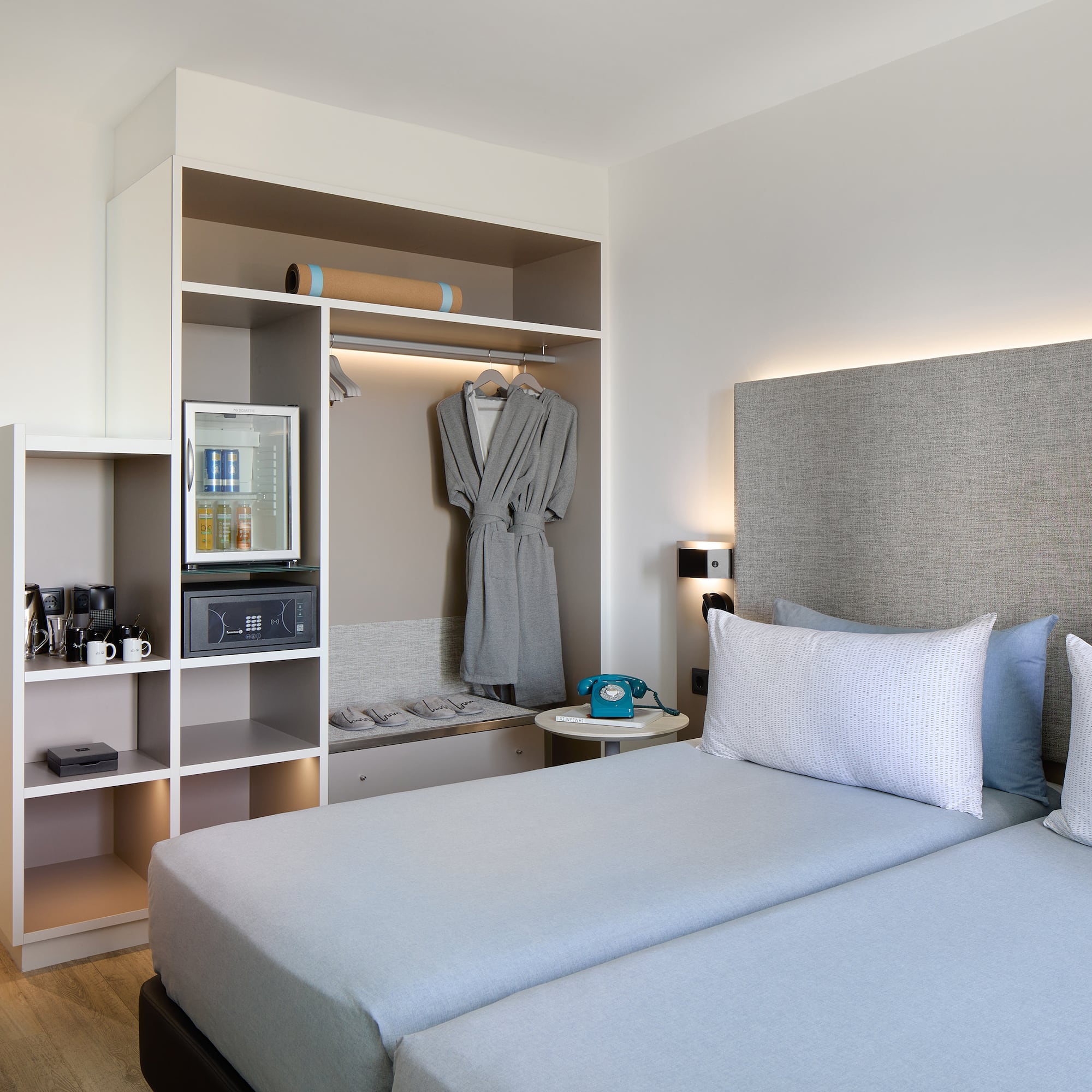 a room with two beds and a shelf