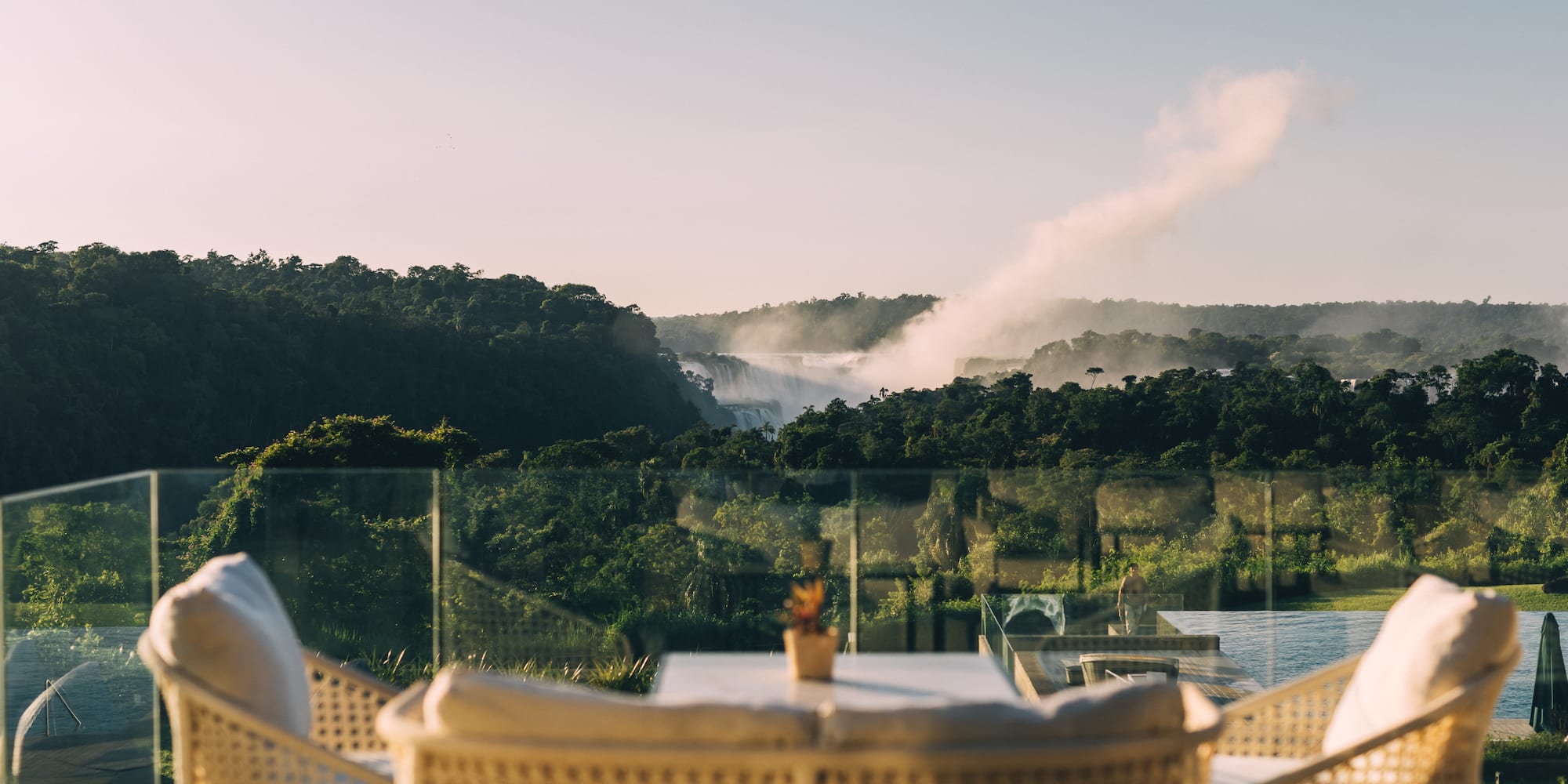 a table and chairs with a view of a river and trees