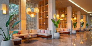 a room with a large couch and plants