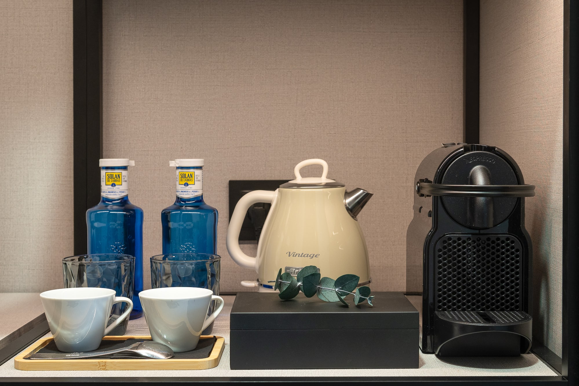 a coffee maker and cups on a table