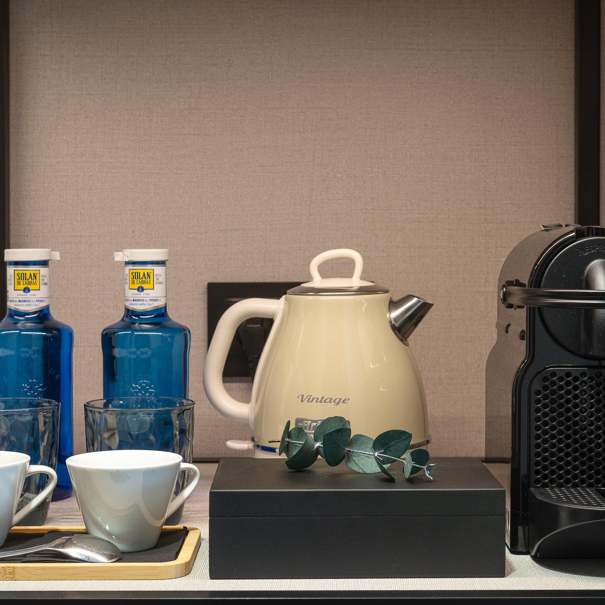 a coffee maker and cups on a table