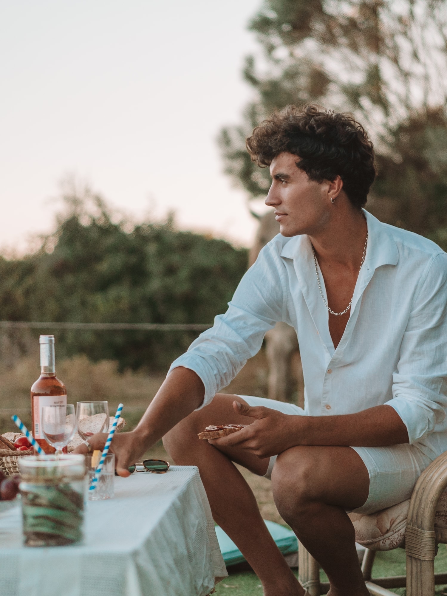 a man sitting at a table with food and drinks