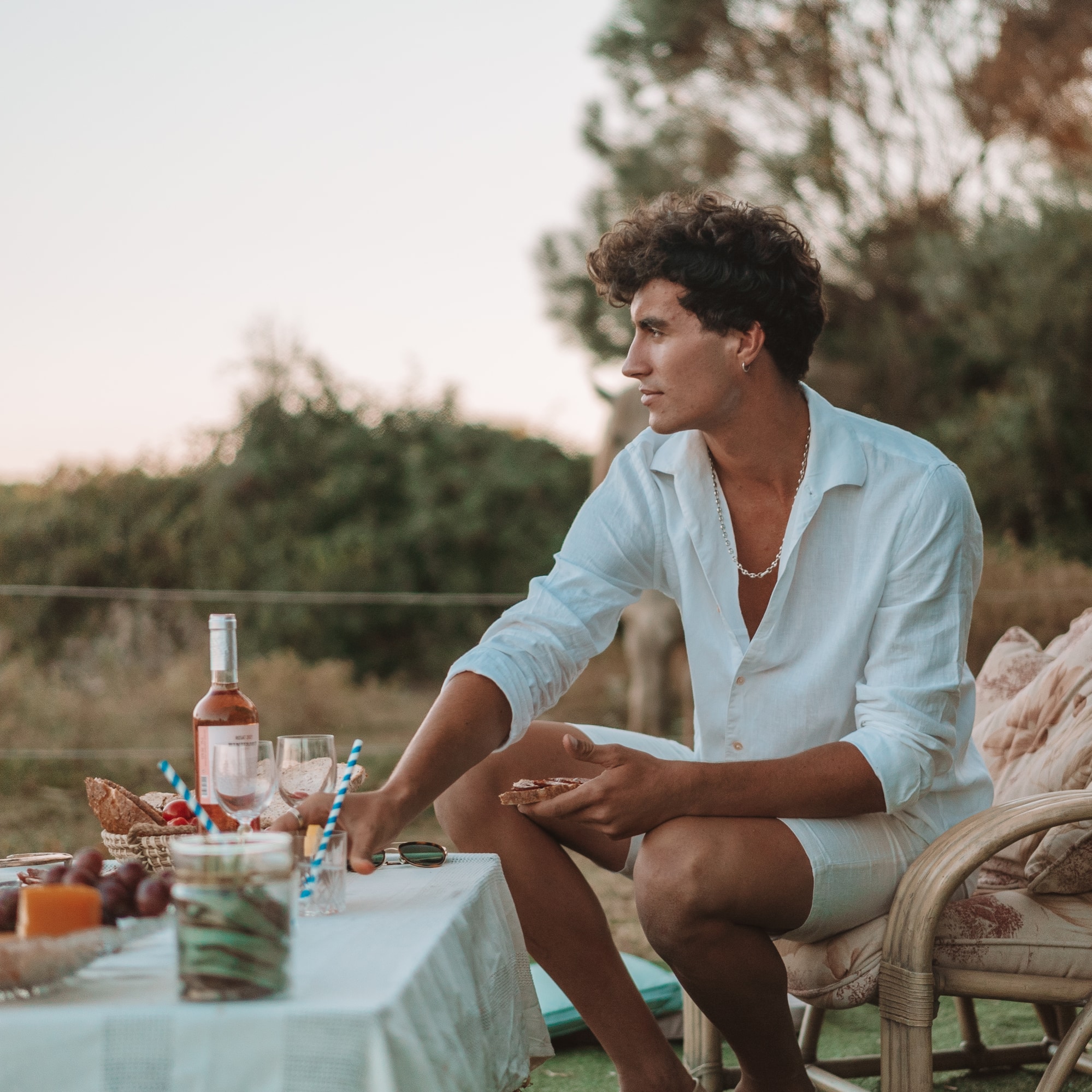 a man sitting at a table with food and drinks