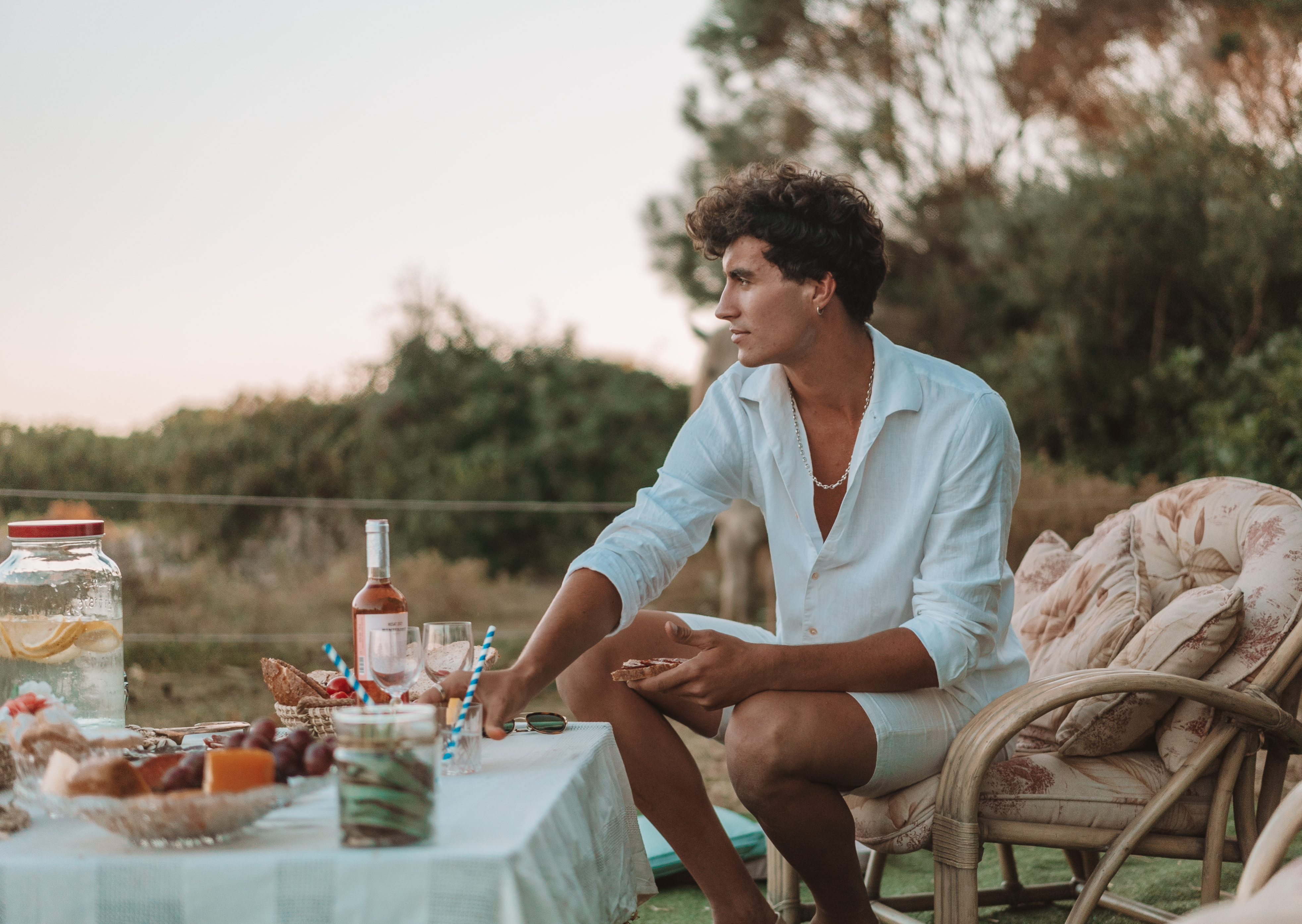a man sitting at a table with food and drinks