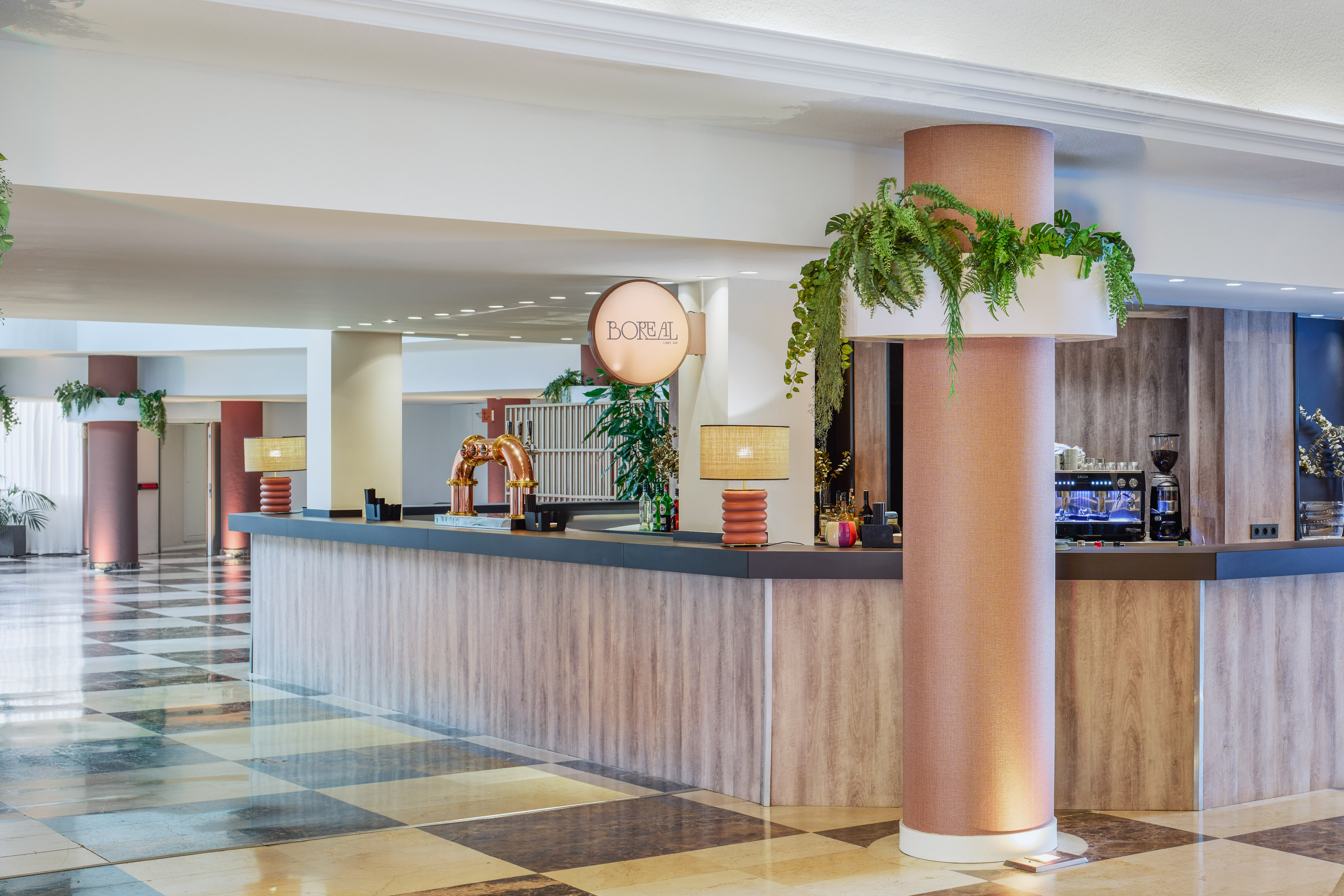 Hotel Boreal lobby bar with modern wood counter, beer taps, and coffee machine.