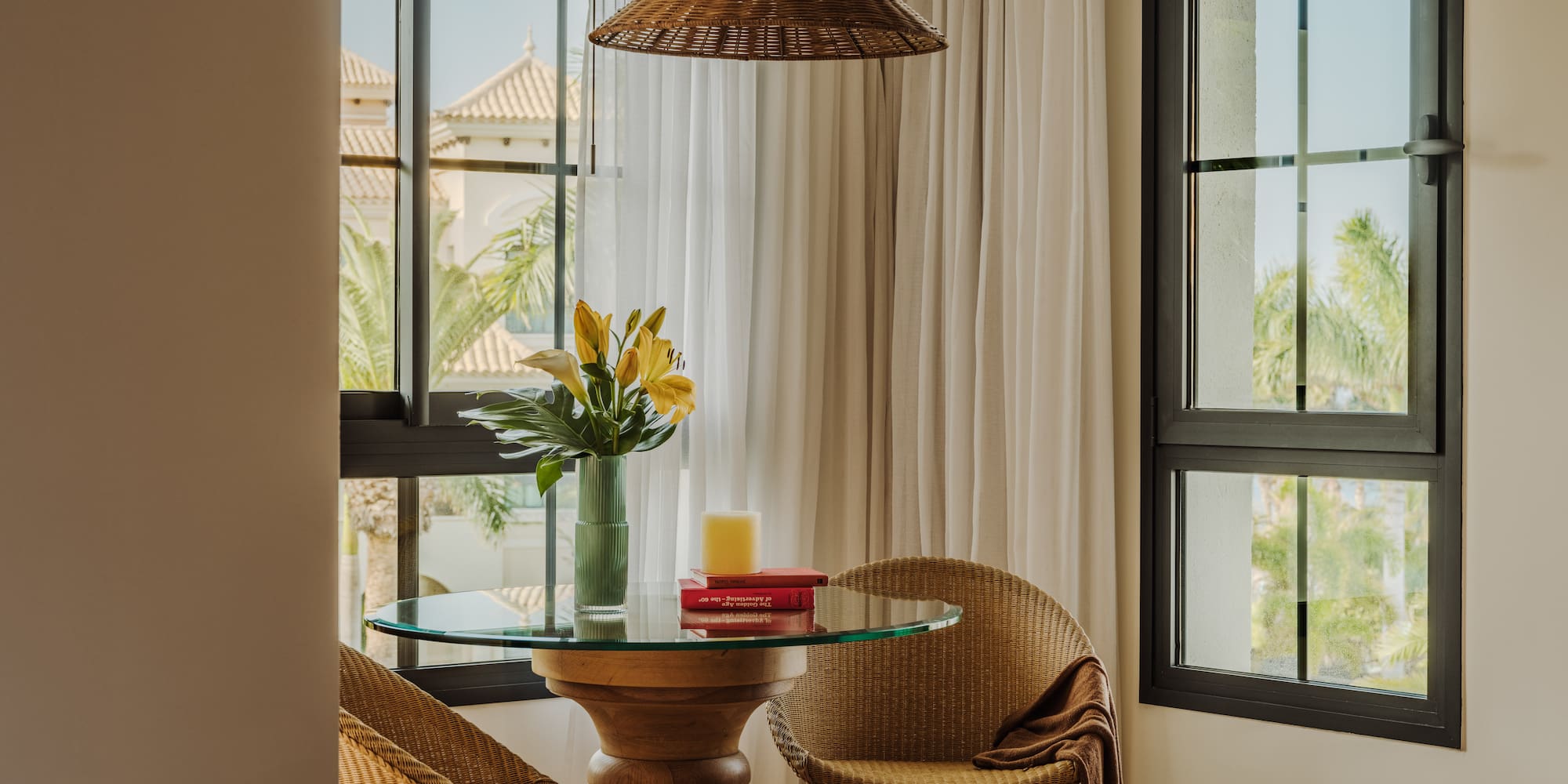 a table with chairs and a vase of flowers