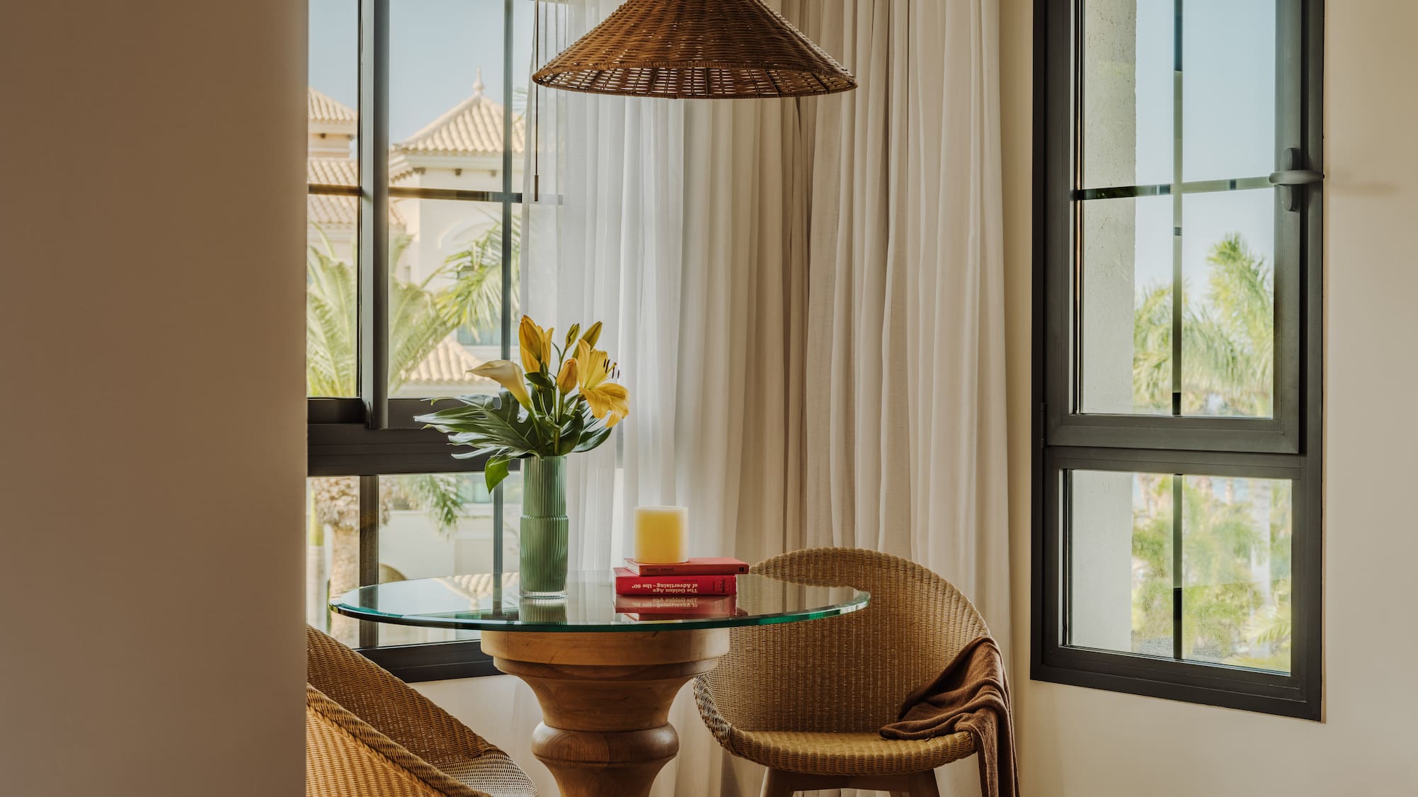 a table with chairs and a vase of flowers