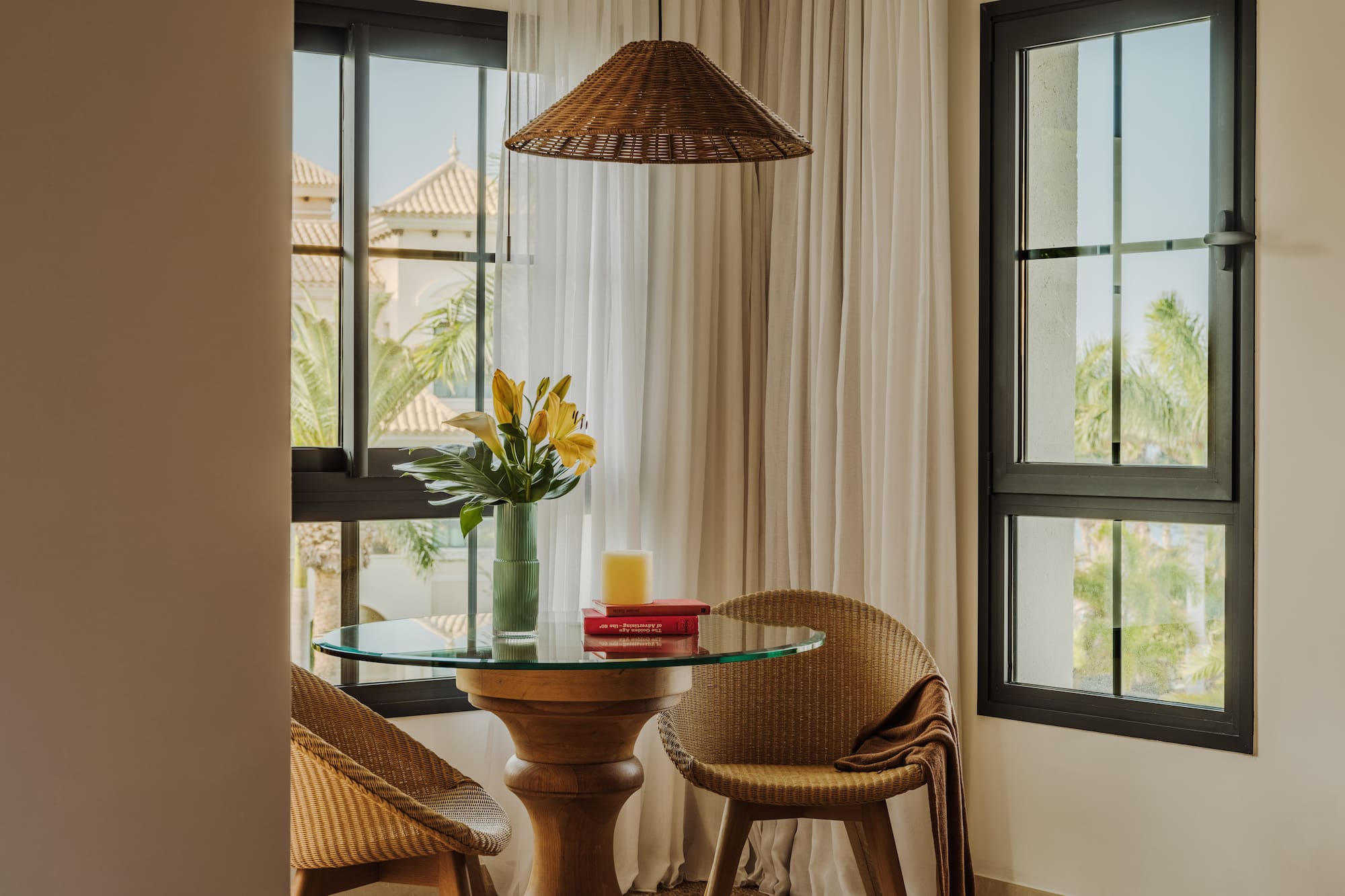 a table with chairs and a vase of flowers