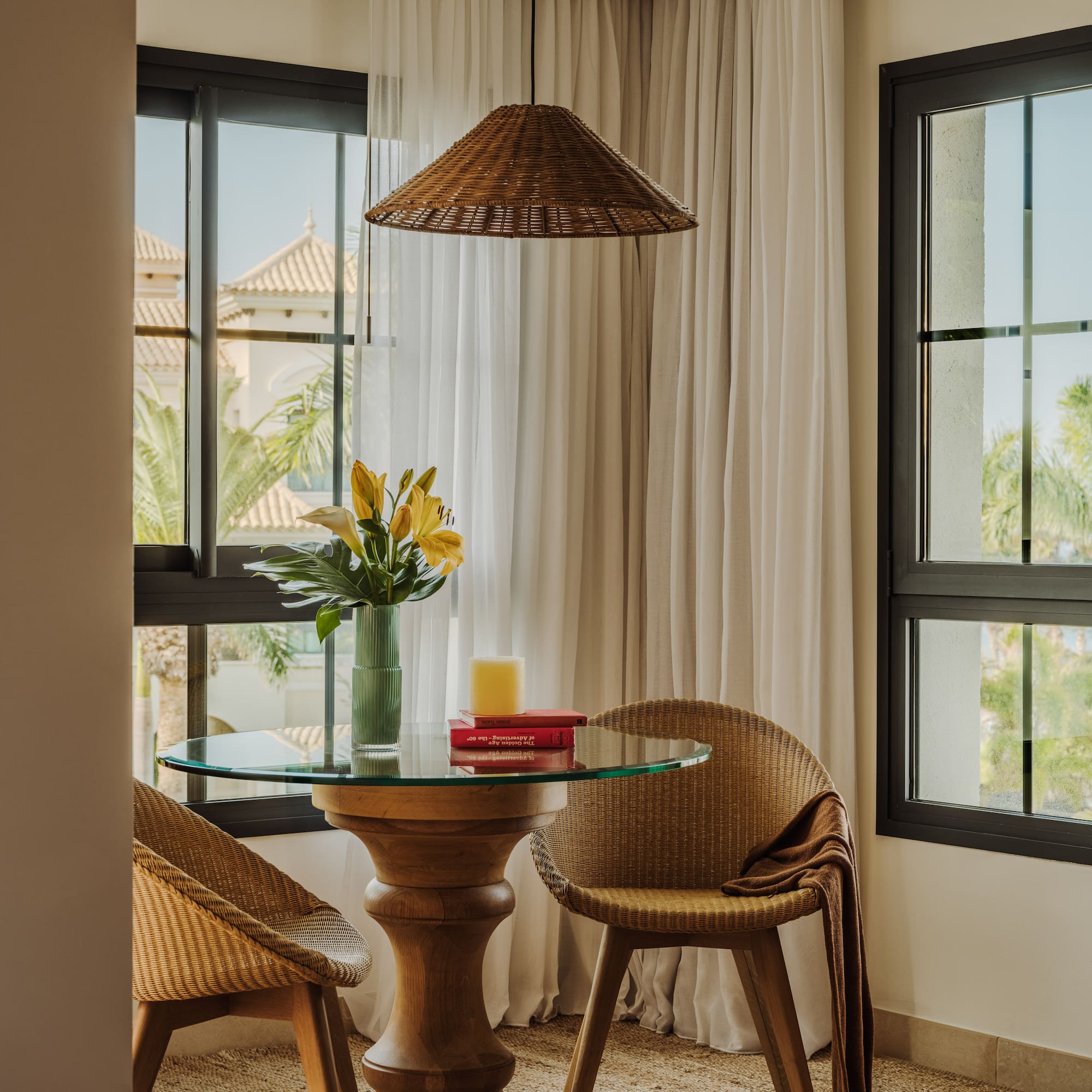 a table with chairs and a vase of flowers