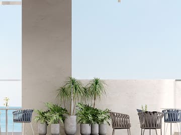 a patio with chairs and tables and plants