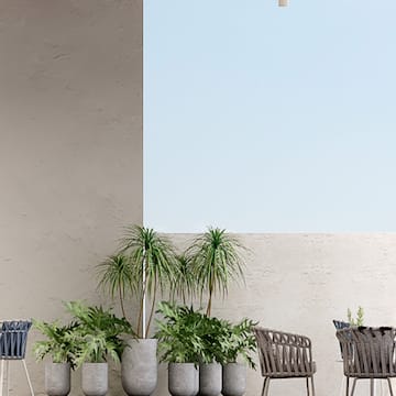 a patio with chairs and tables and plants