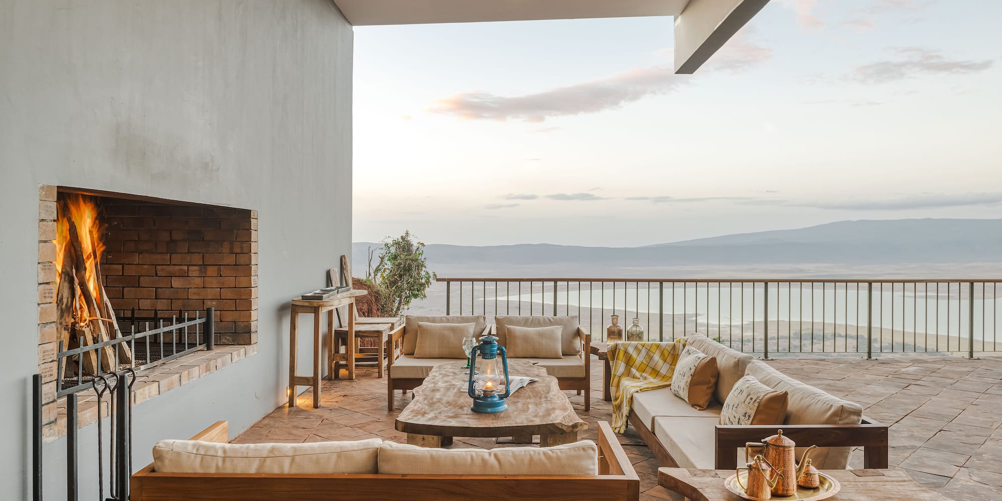 a patio with a view of the ocean and a fireplace