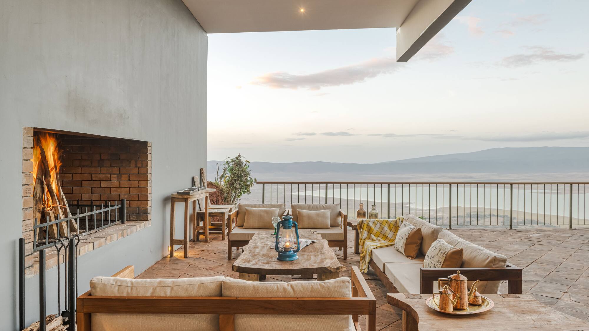 a patio with a view of the ocean and a fireplace