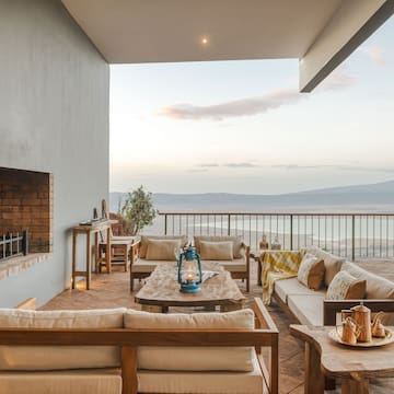 a patio with a view of the ocean and a fireplace
