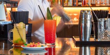 a man behind a bar with drinks
