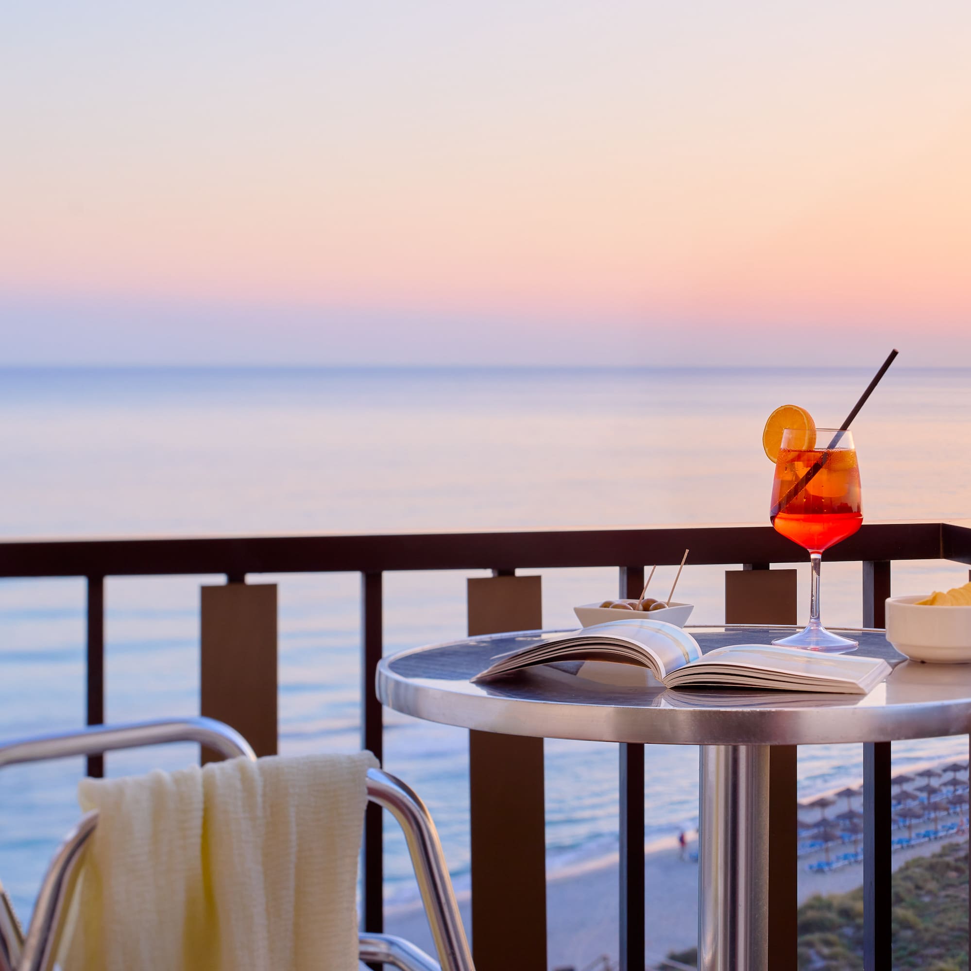 a table with a drink and a book on it