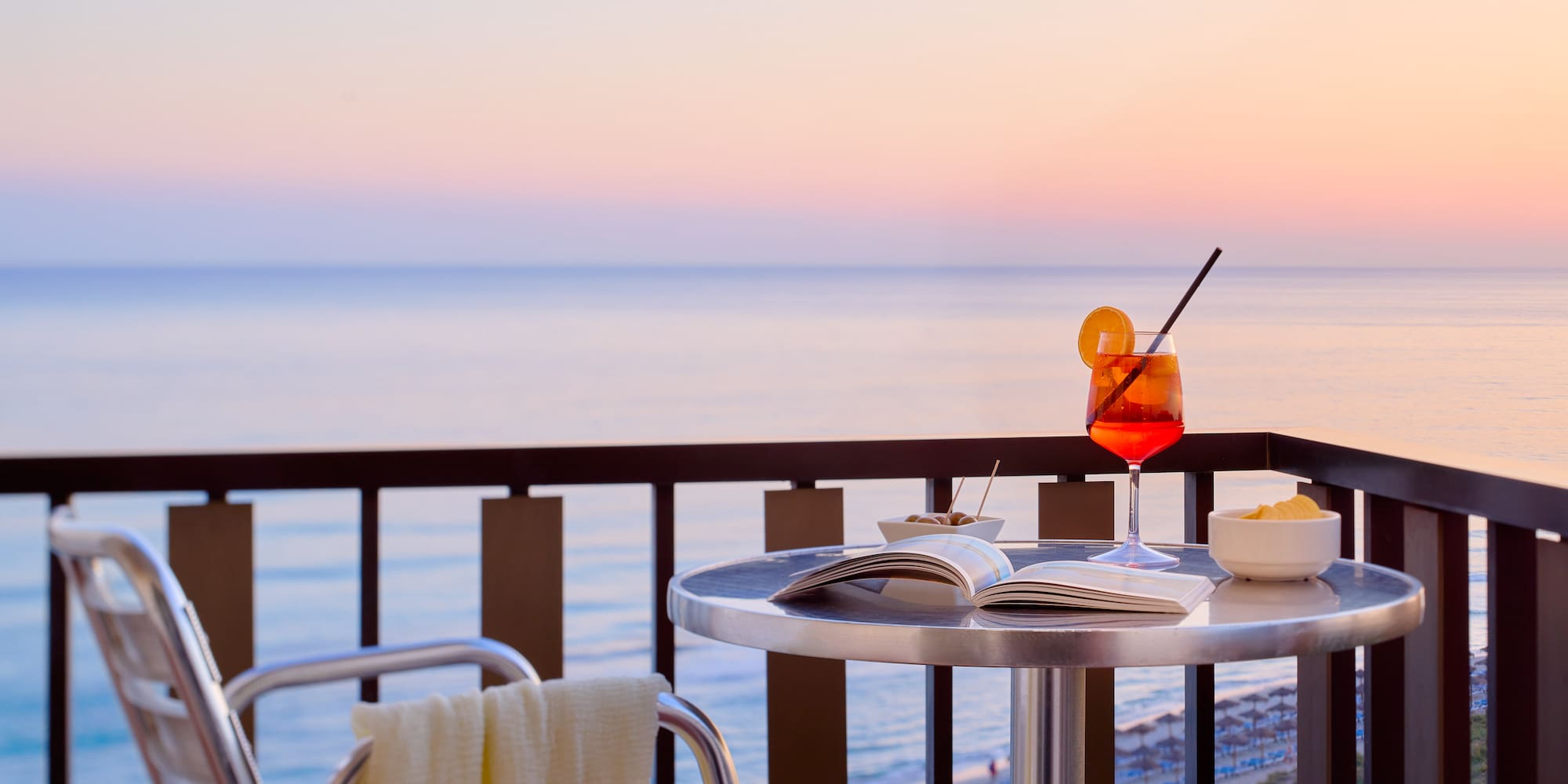 a table with a drink and a book on it