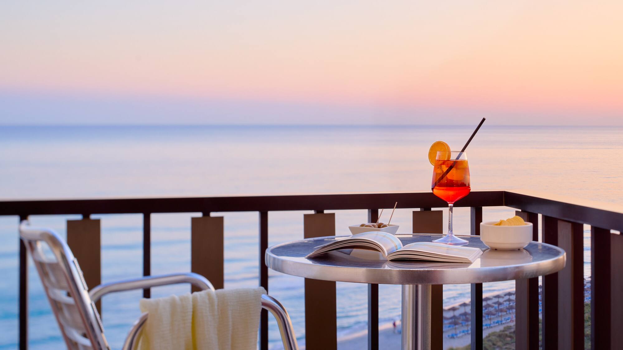 a table with a drink and a book on it