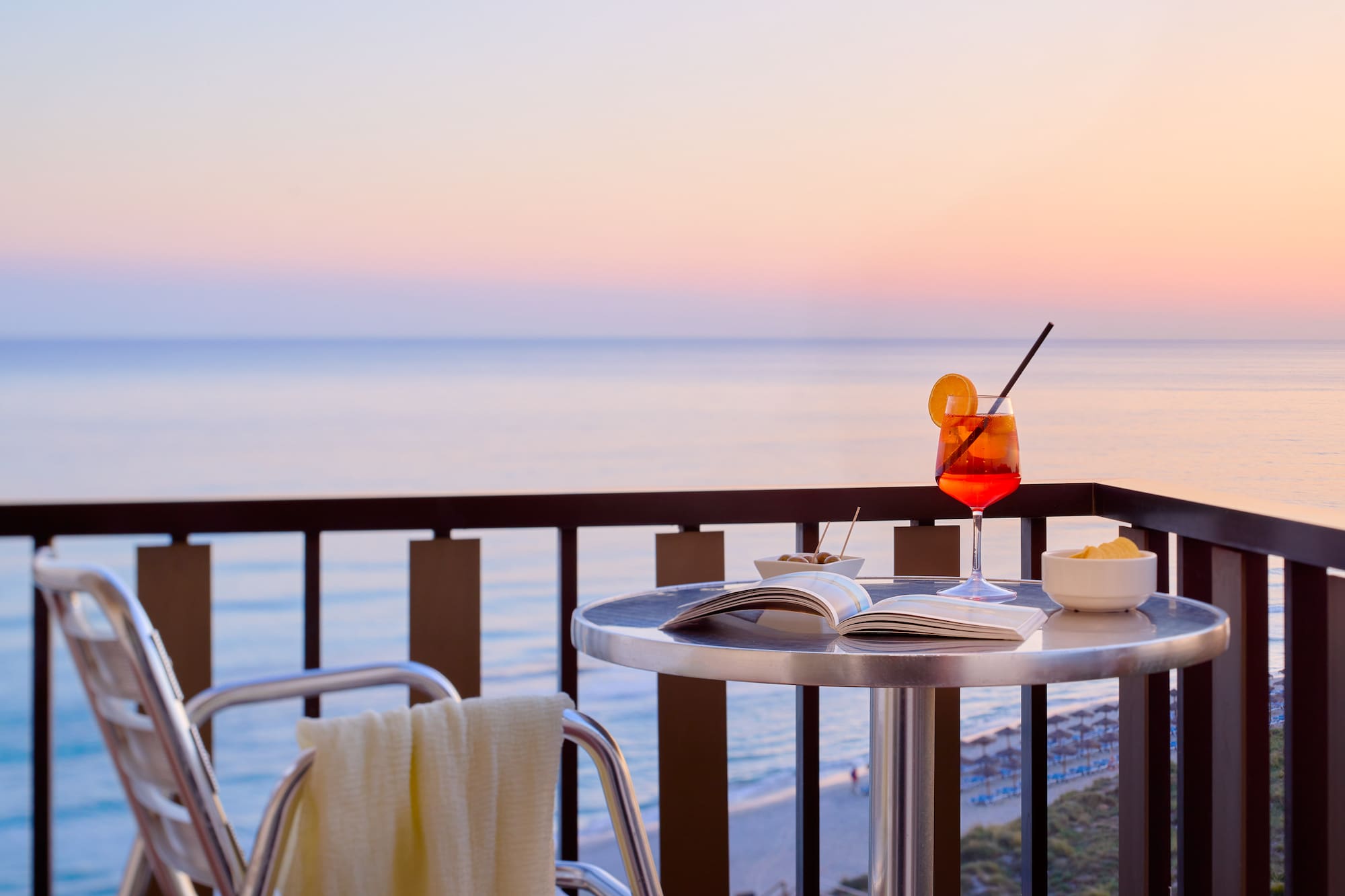 a table with a drink and a book on it