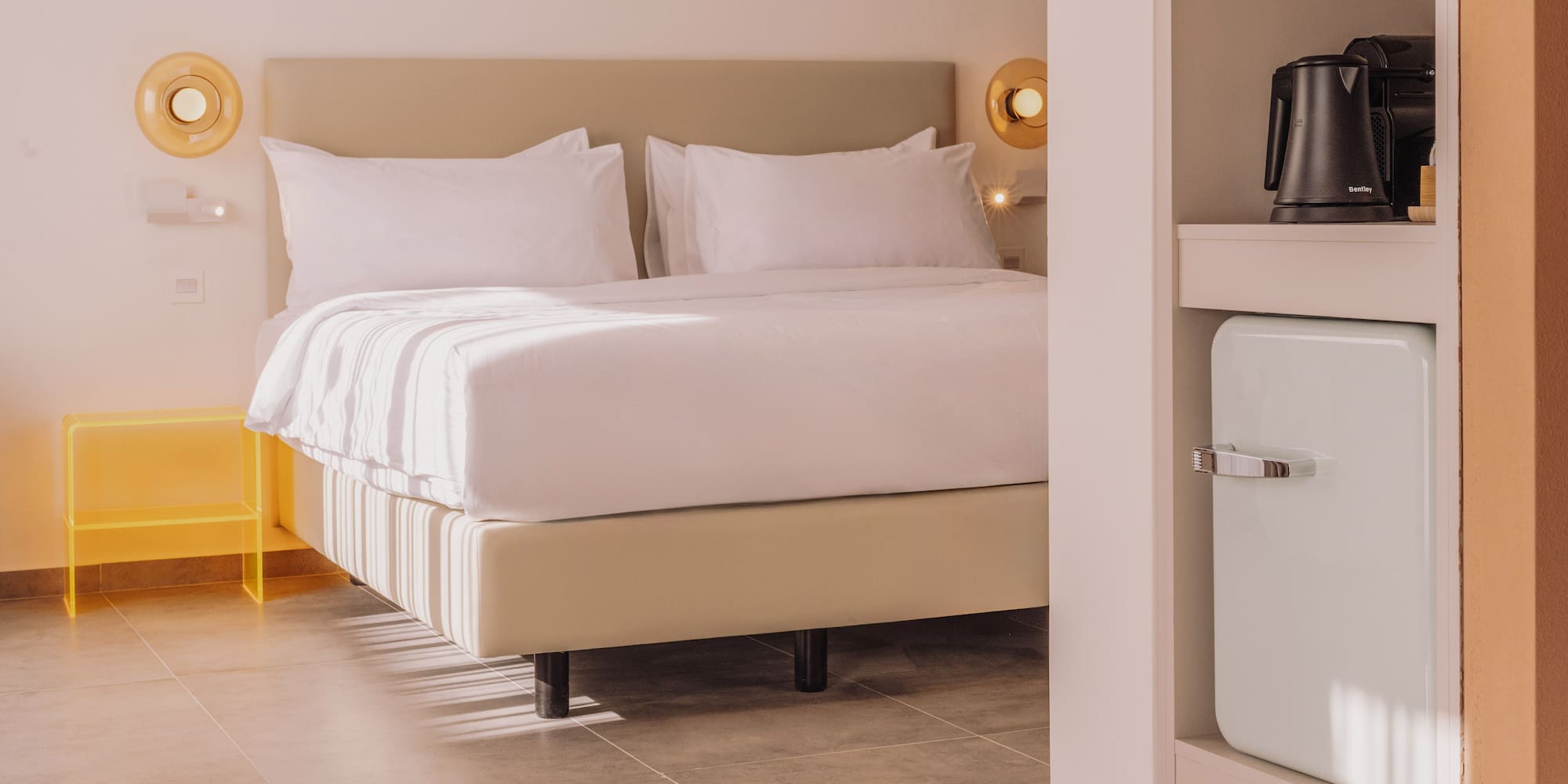 a bed with white sheets and a microwave