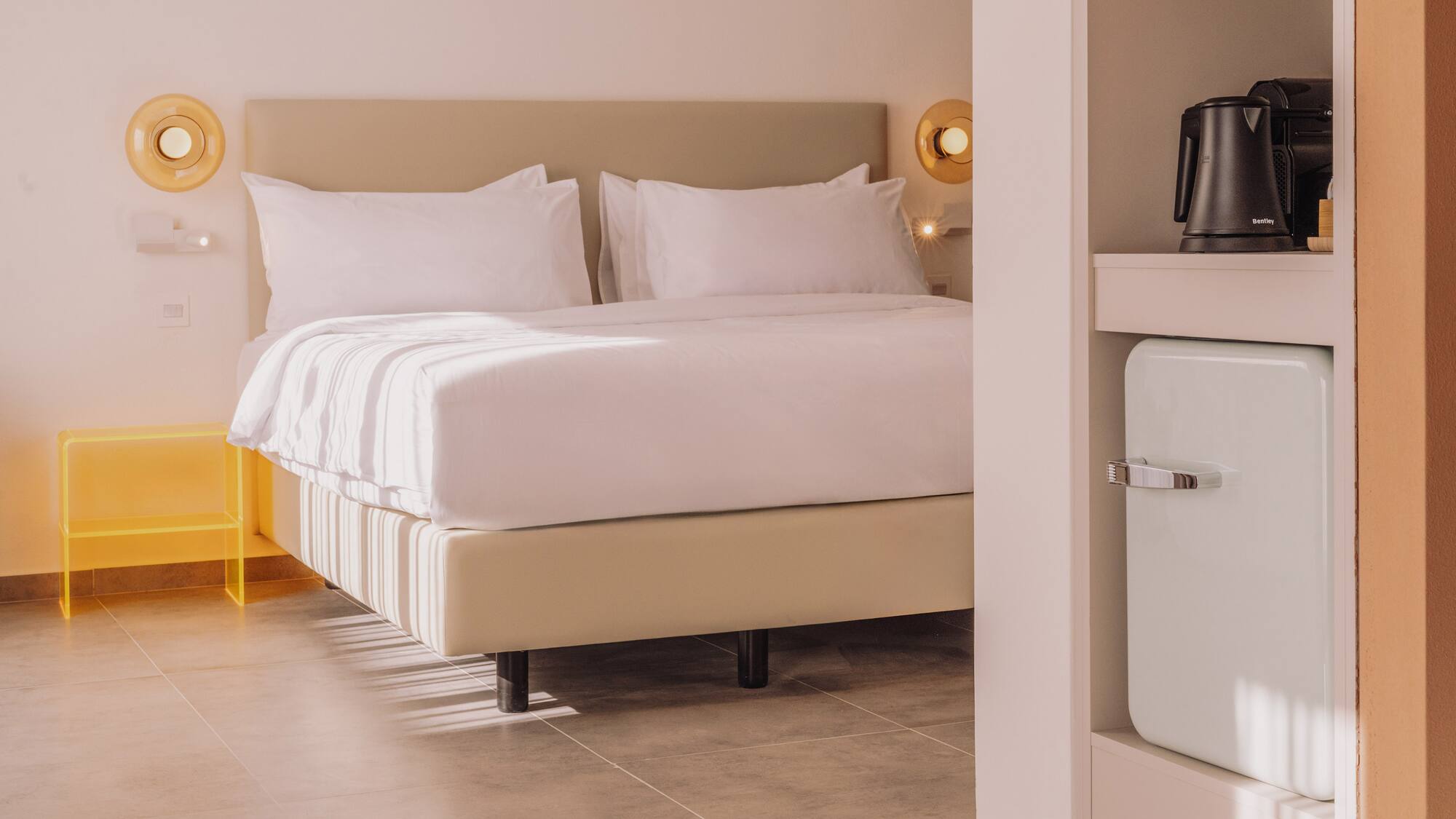 a bed with white sheets and a microwave