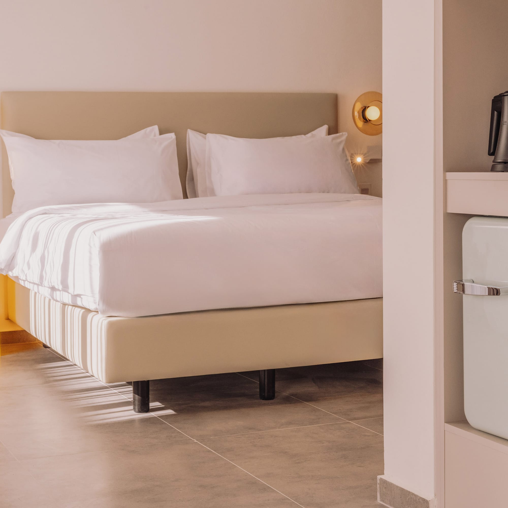 a bed with white sheets and a microwave