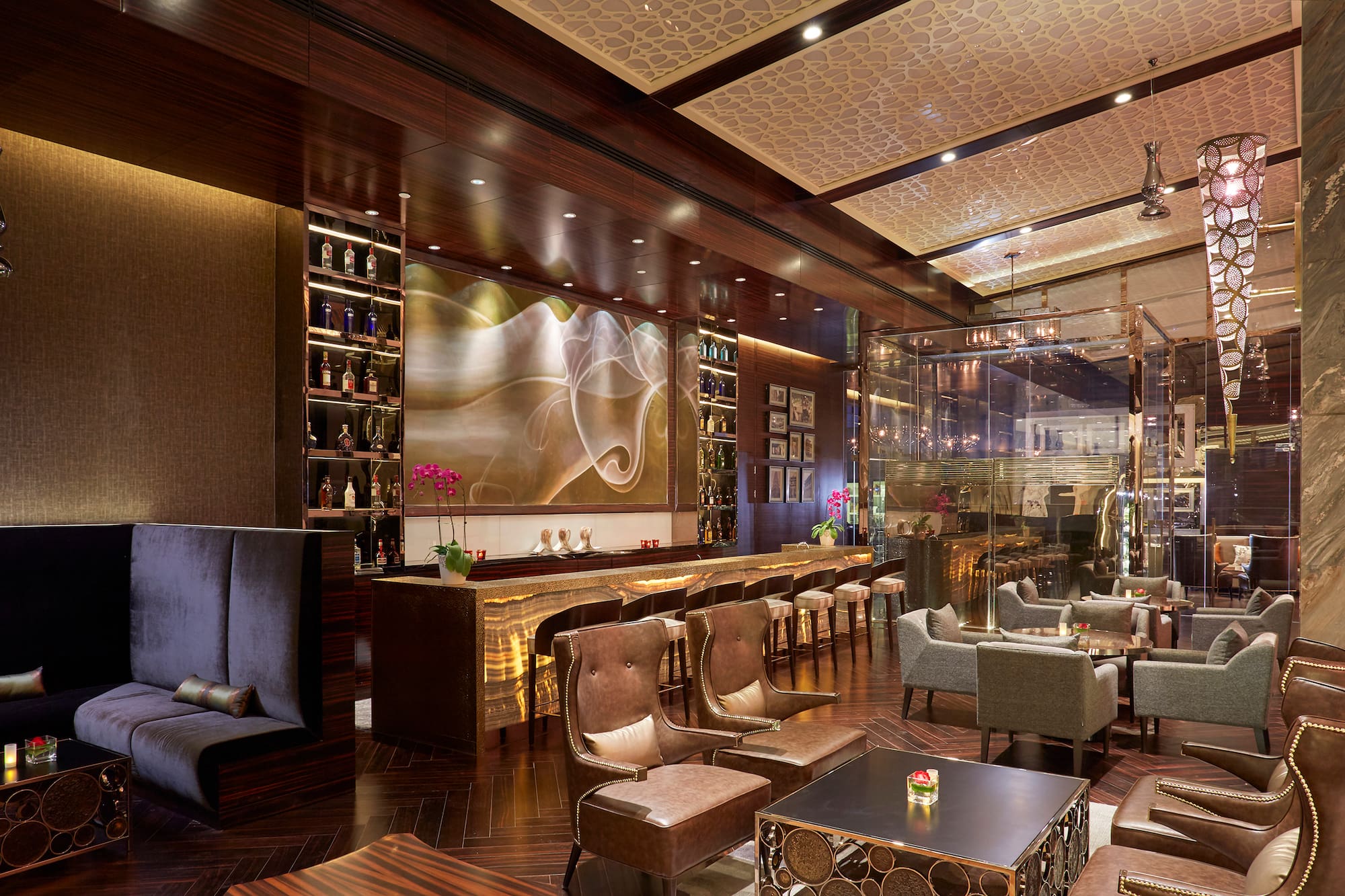 Luxury bar lounge interior with dark wood, plush seating, and ambient lighting.