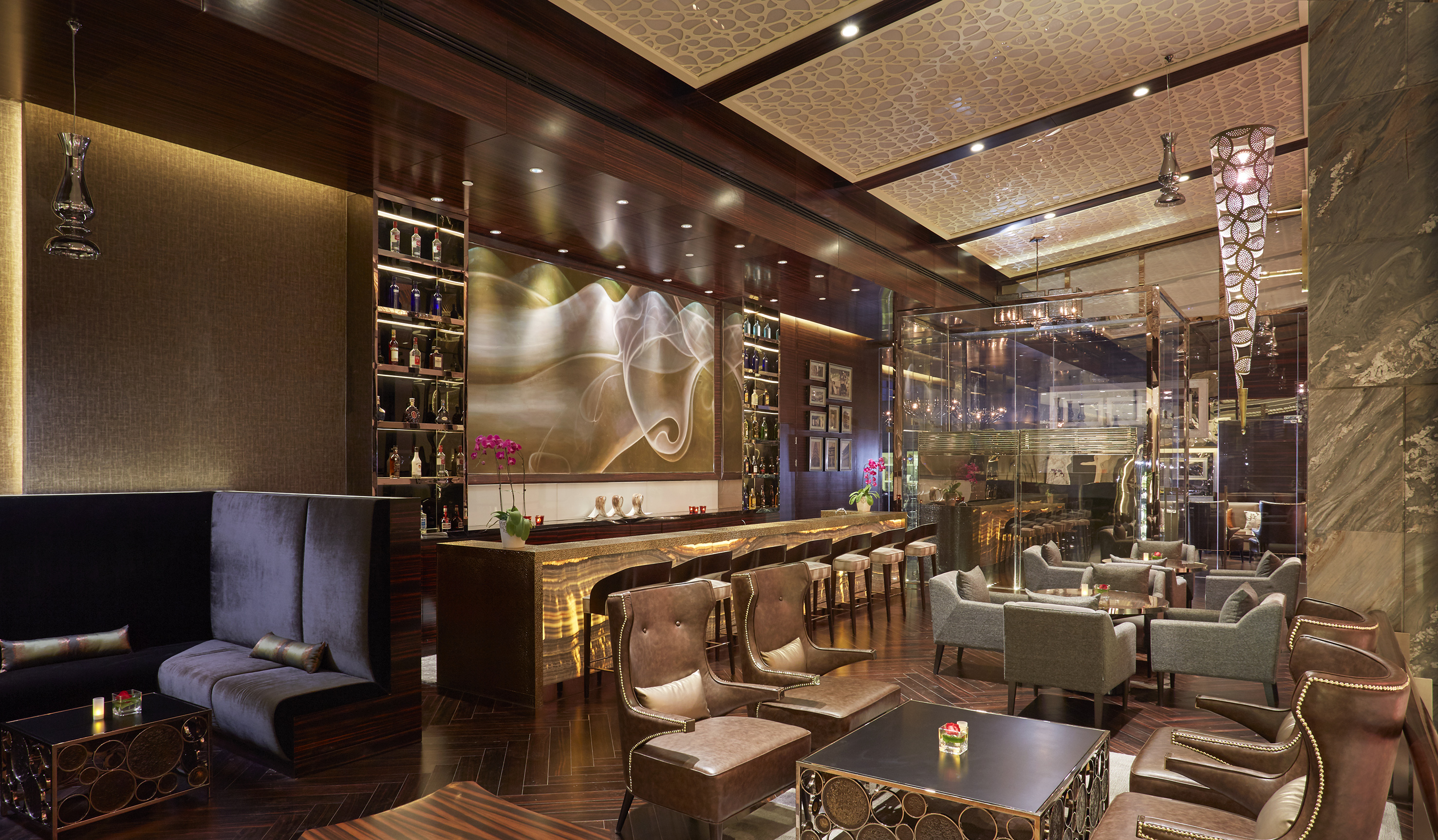 Luxury bar lounge interior with dark wood, plush seating, and ambient lighting.