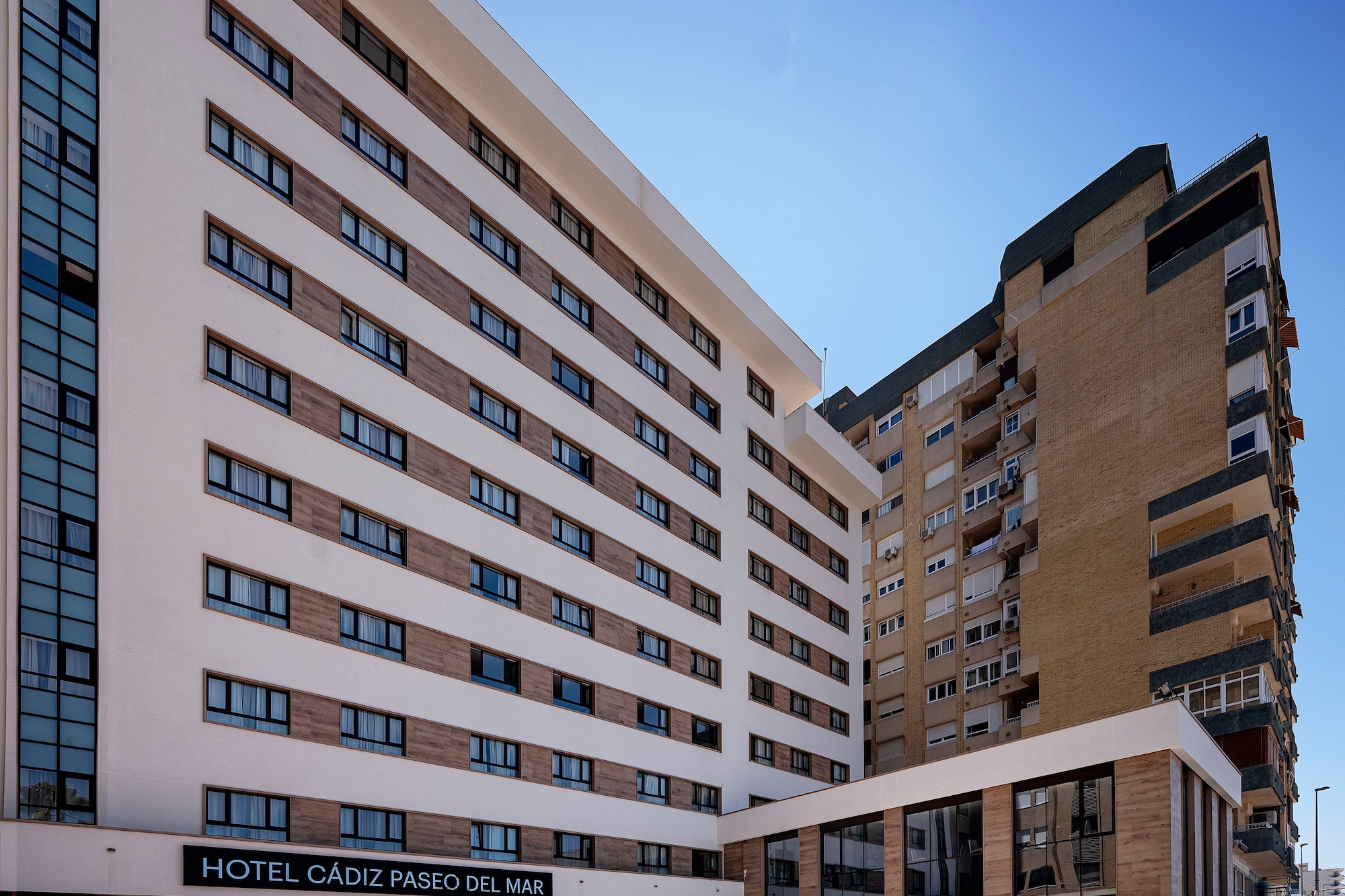Hotel Cádiz Paseo del Mar exterior, modern white building with outdoor patio.