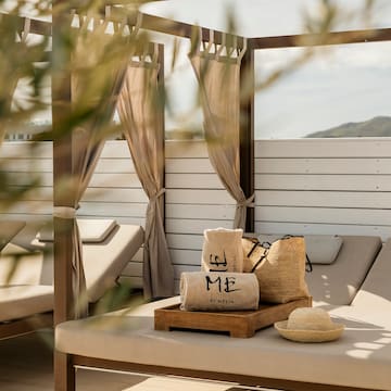 a lounge chair with a hat and bags on it