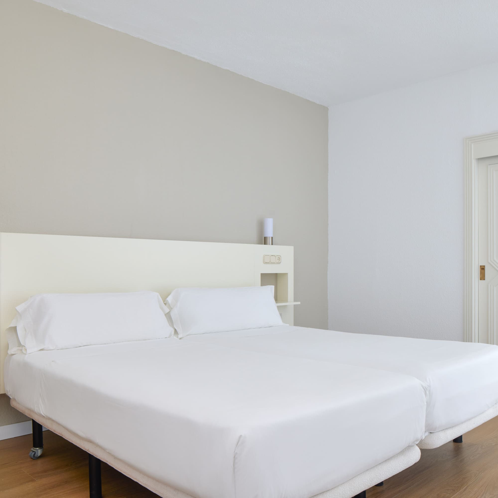 a bed with white sheets in a room
