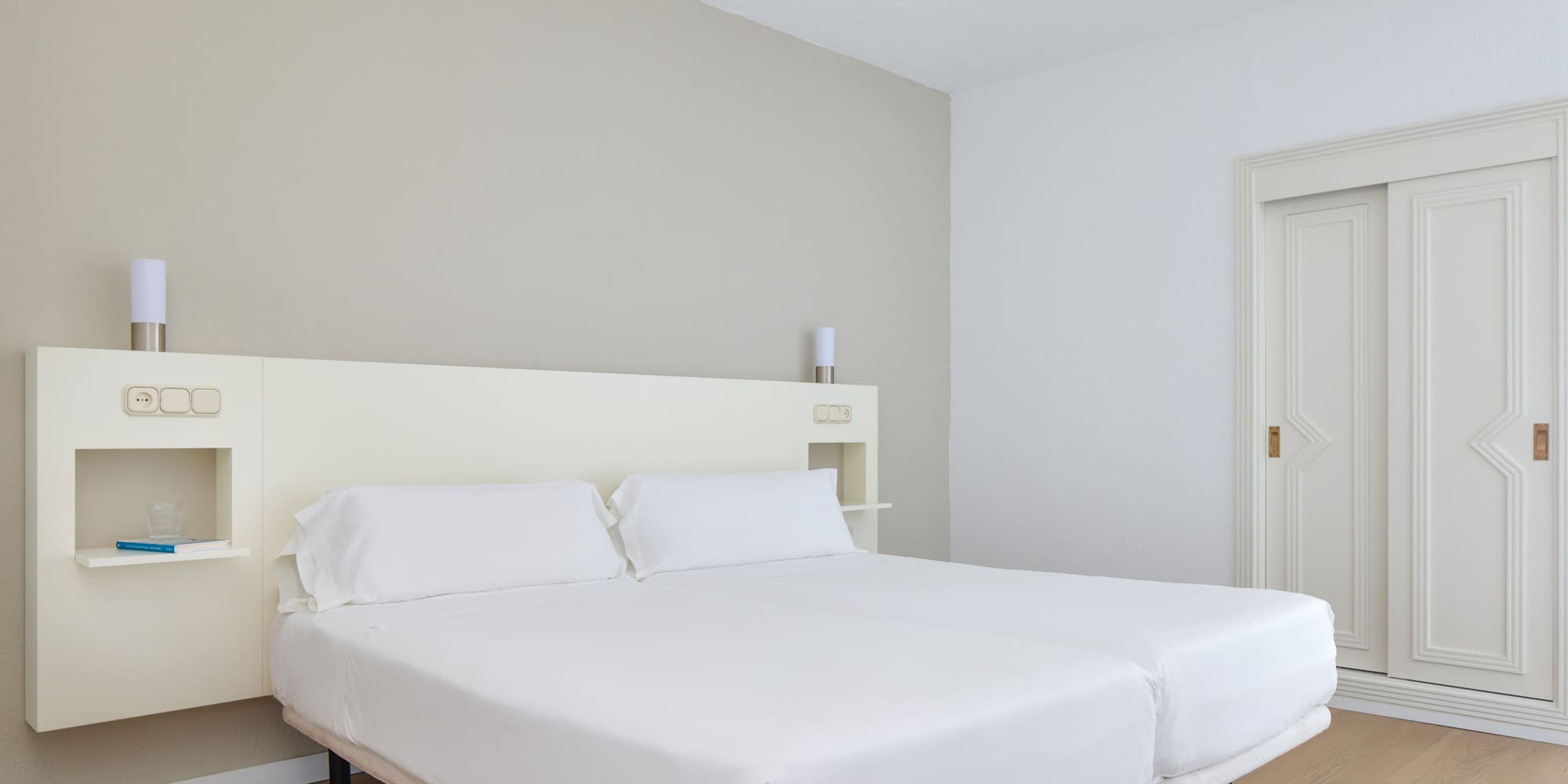 a bed with white sheets in a room